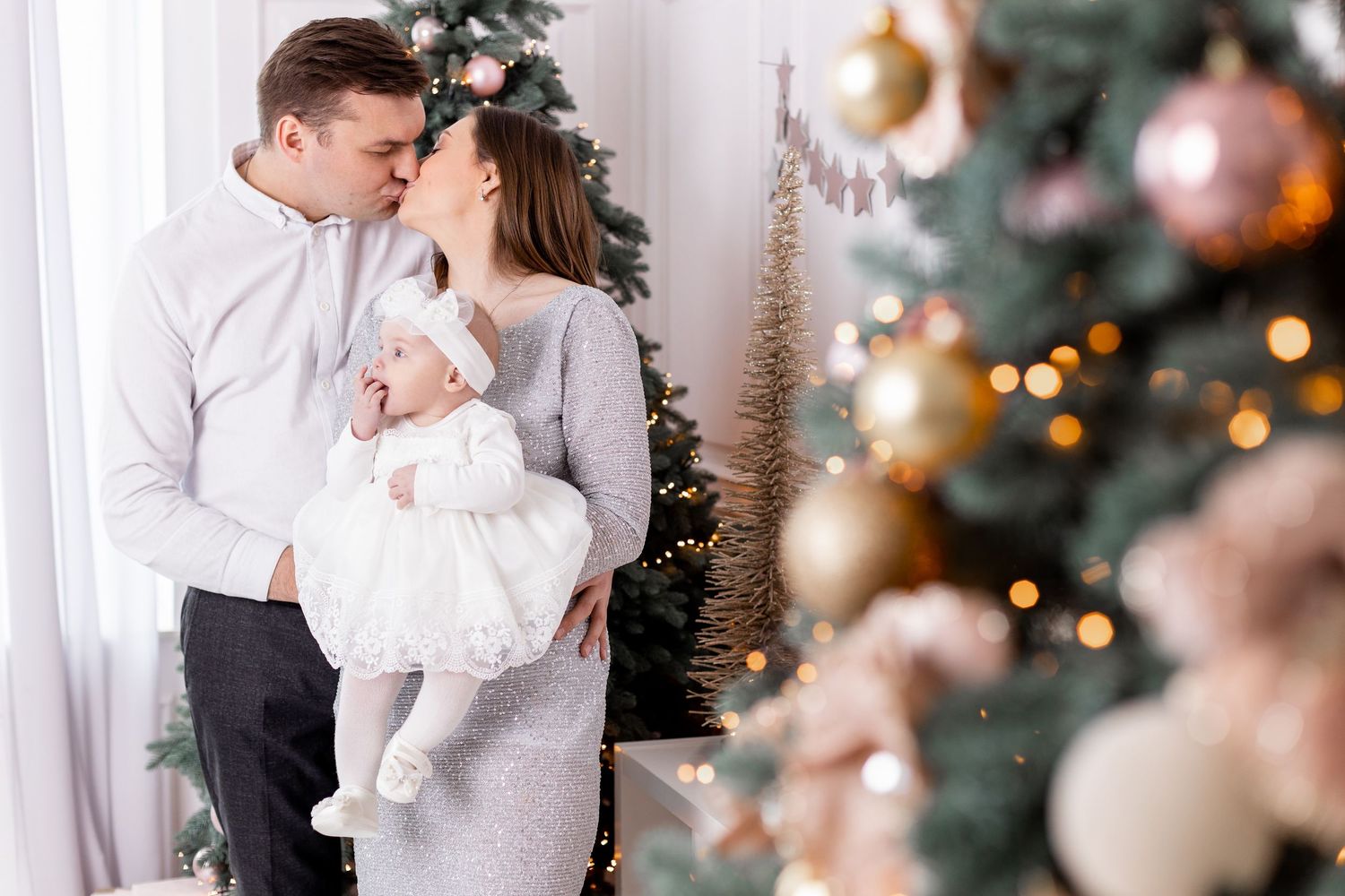 Intimate holiday portrait session with white and gold Christmas decorations.