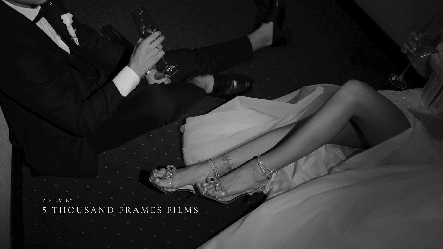 Black and white wedding film still showing bride and groom seated, captured by 5 Thousand Frames Films.