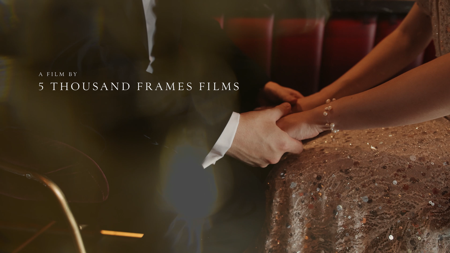 Couple holding hands tenderly, with text overlay reading A Film By 5 Thousand Frames Films in elegant cinematic style.