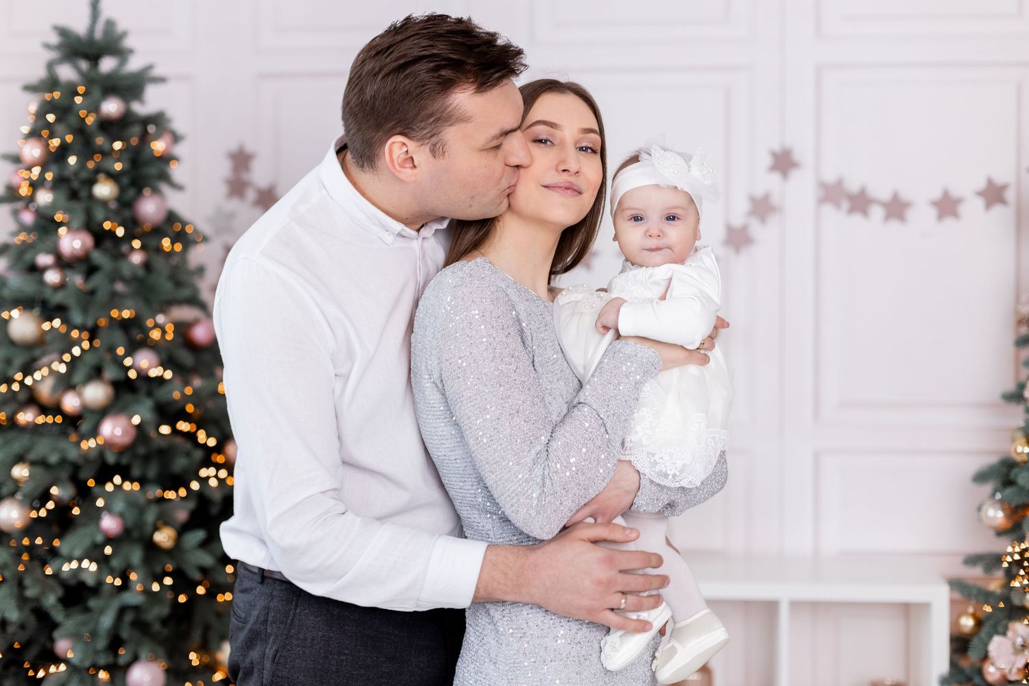 Sweet family interactions during holiday photoshoot with decorated Christmas tree.