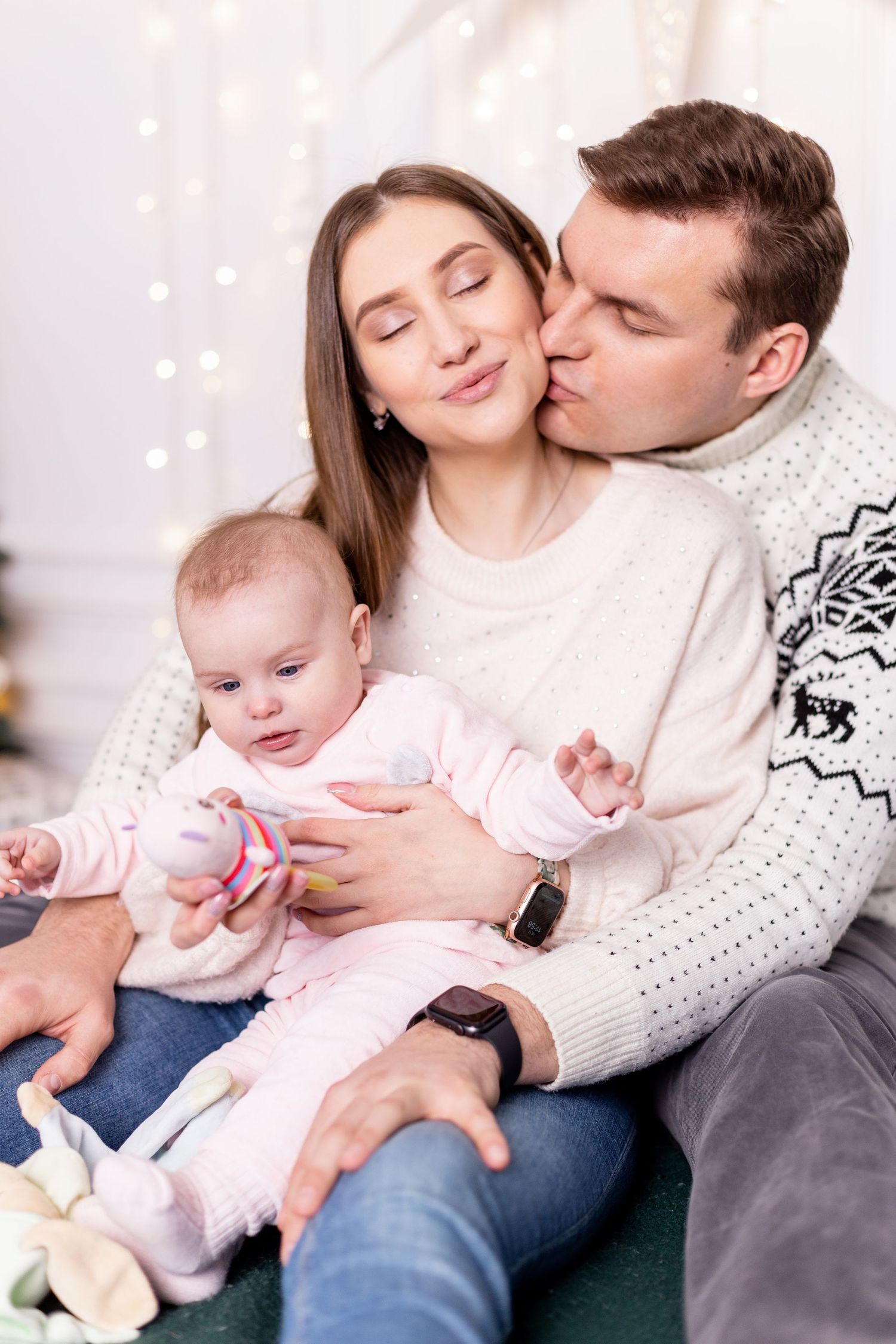Intimate family moments captured on green couch with festive Christmas backdrop.