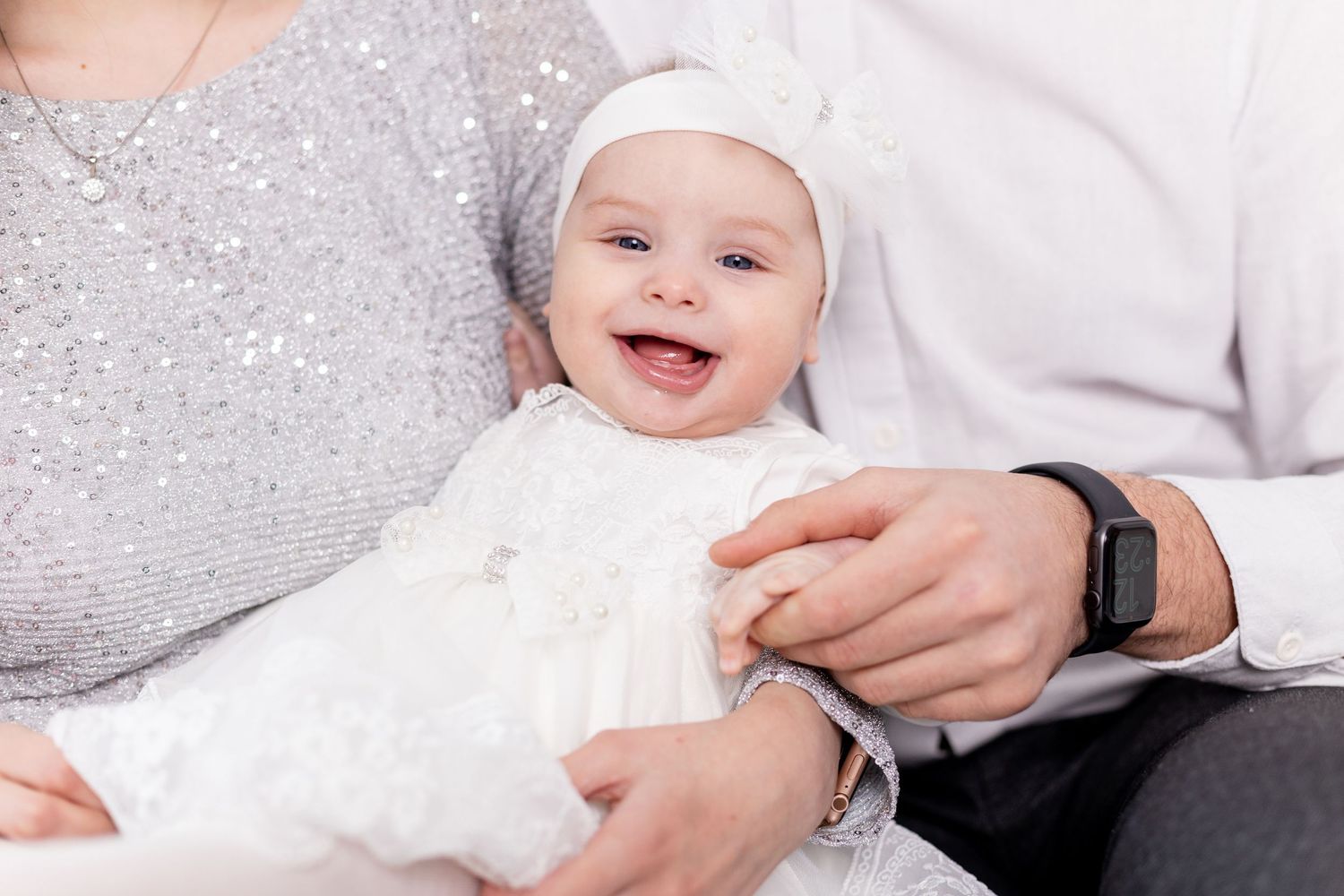 Close-up shots during winter family photoshoot with sparkly silver details.