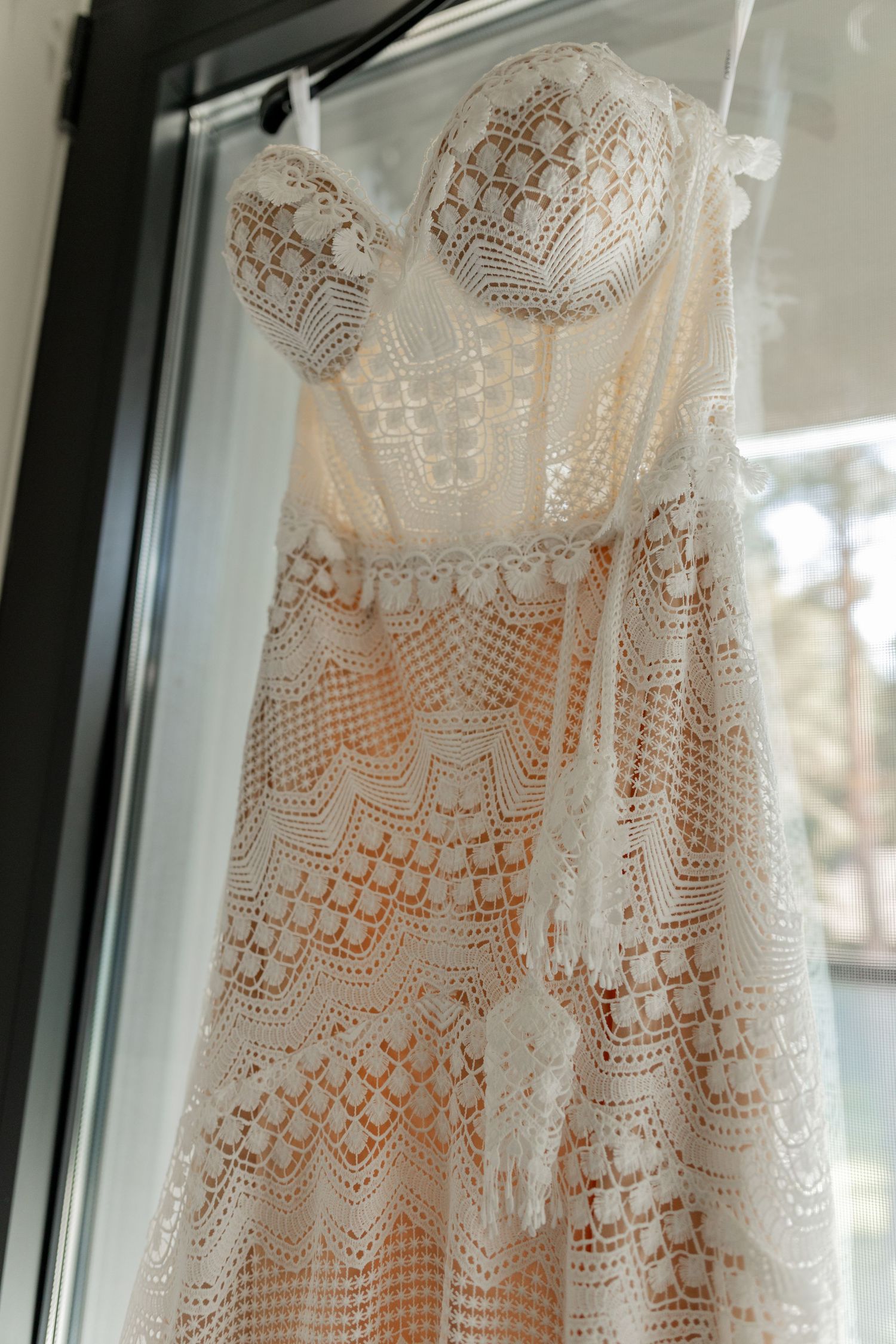 Close-up of an intricate lace wedding dress with detailed pattern work.