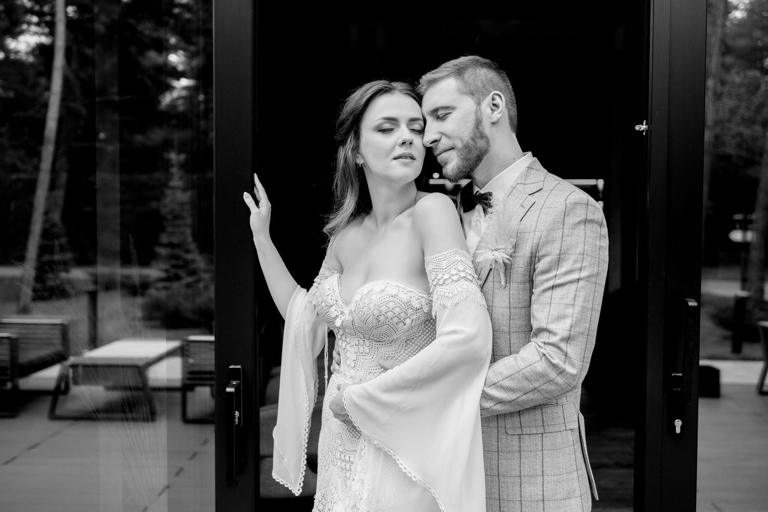 Black and white wedding portraits showing tender moments between newlyweds outside a modern venue.