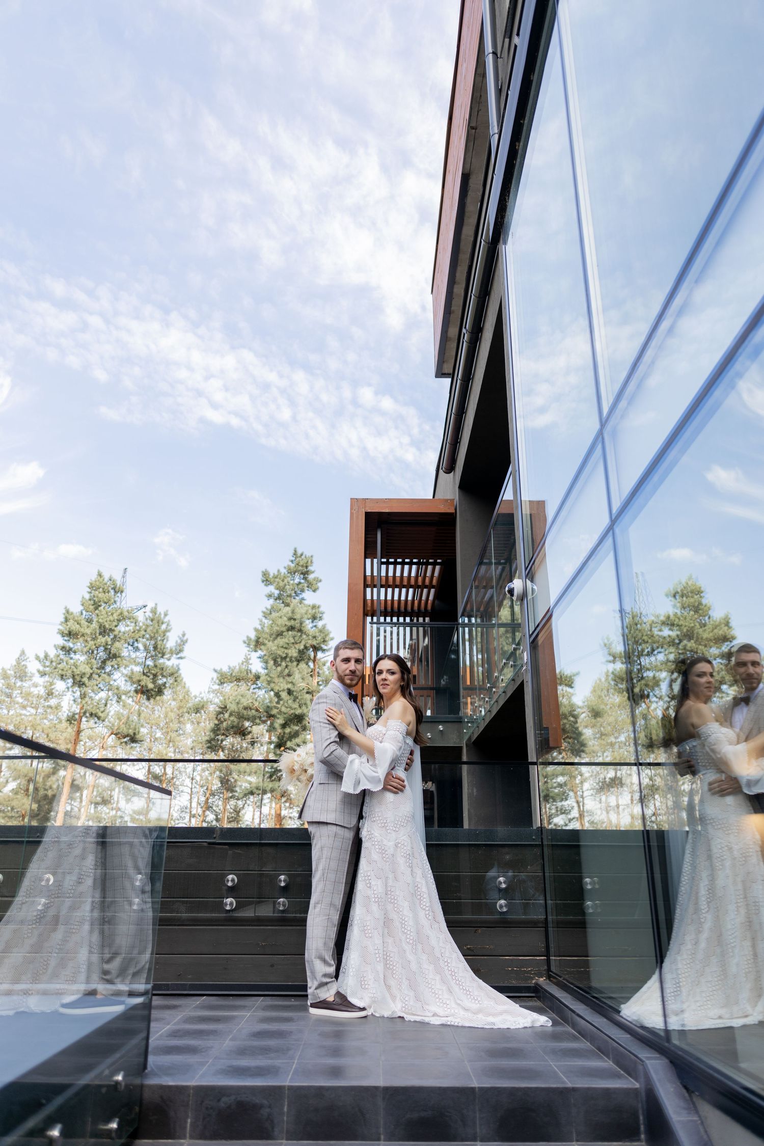 Series of romantic wedding moments captured against reflective glass windows and modern architecture.