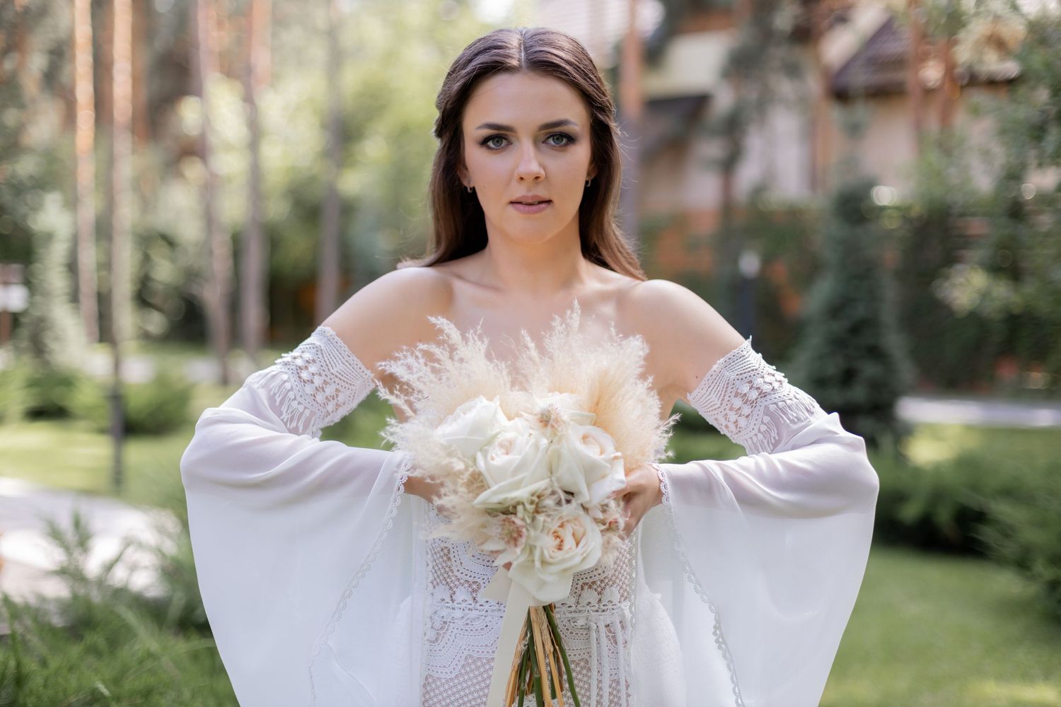 Close-up shots of bride with dried flower bouquet in garden setting.