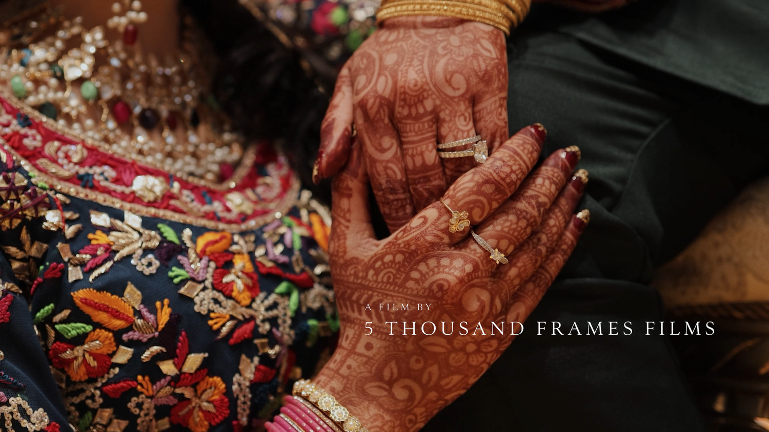 Close-up of intricate henna-adorned hands of an Indian bride and groom during a traditional wedding ceremony.