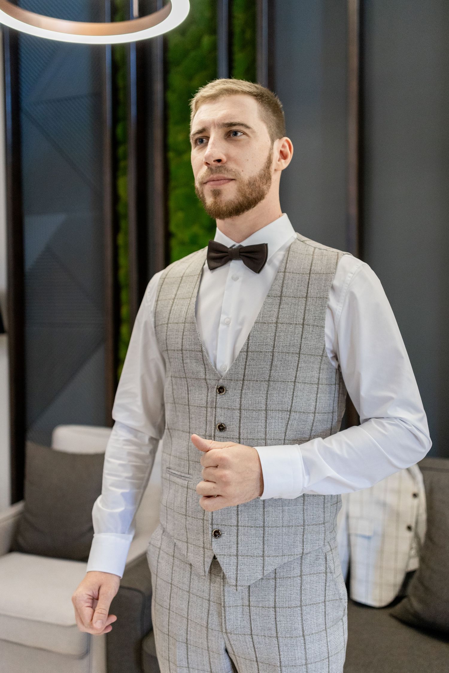 Elegant three piece windowpane suit with bow tie photographed in contemporary space.