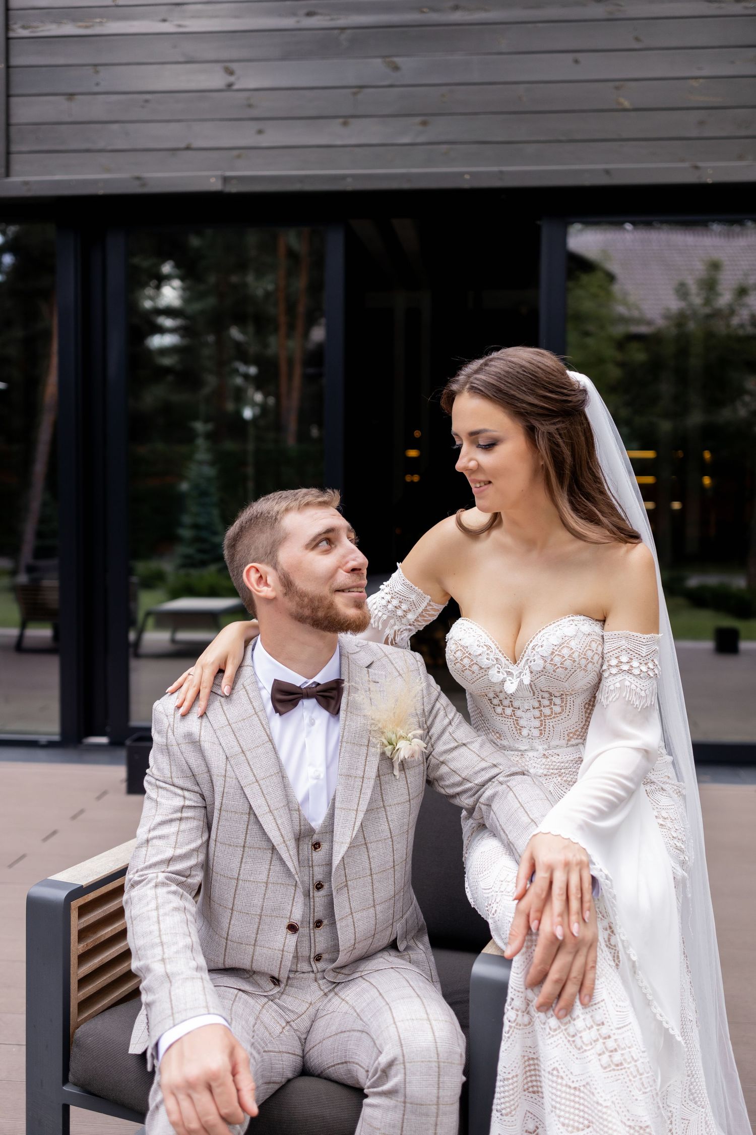 Wedding couple in white and light gray attire share intimate moments during outdoor photoshoot.