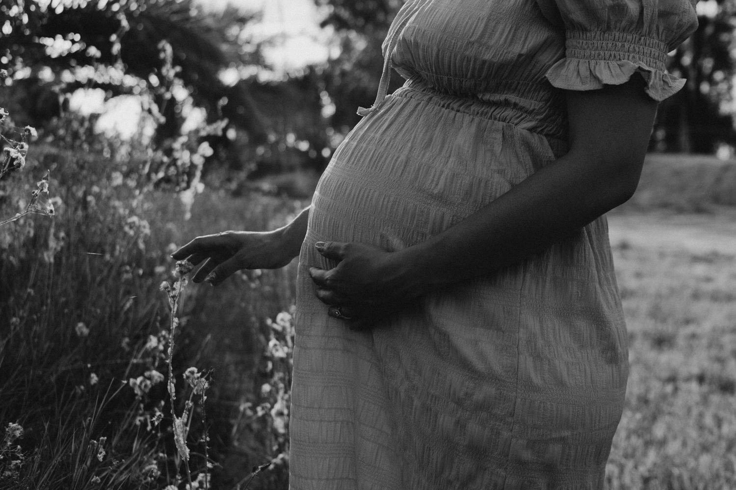 Black and white outdoor maternity photos showing tender moments in nature.