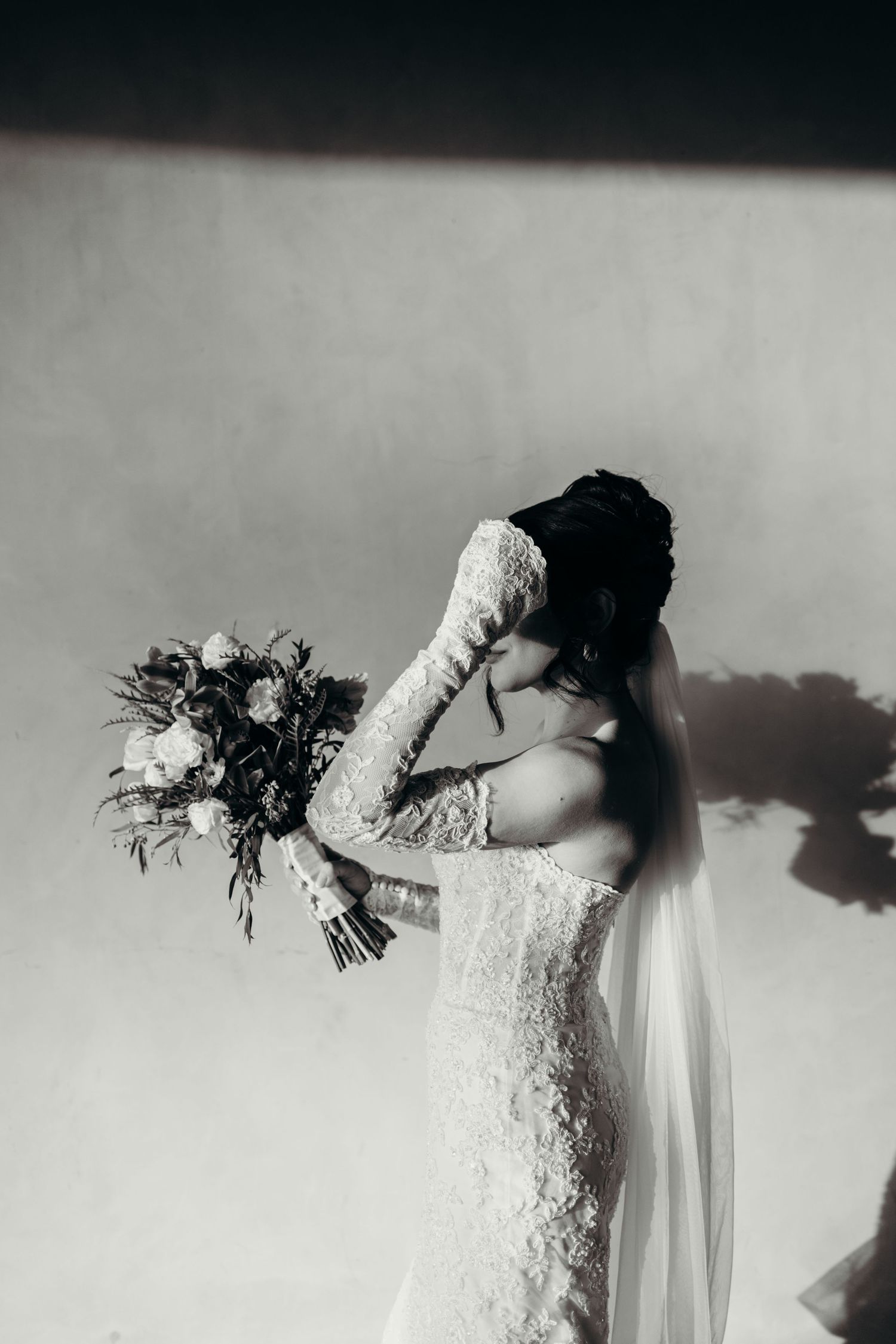 A series of black and white photos showing a person in a lace wedding dress holding a bouquet in artistic poses.