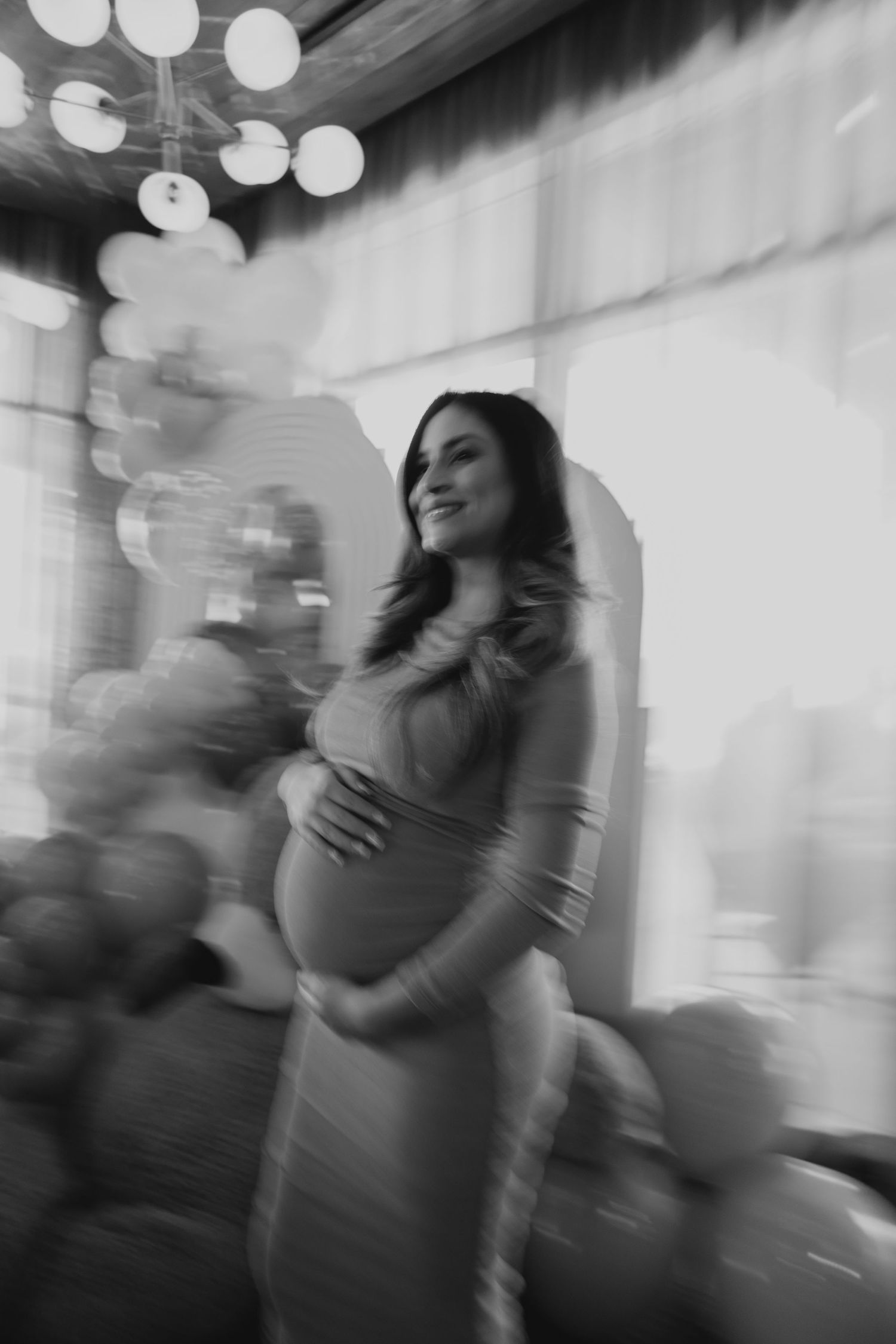 Artistic black and white motion blur sequence showing an emotional maternity moment.