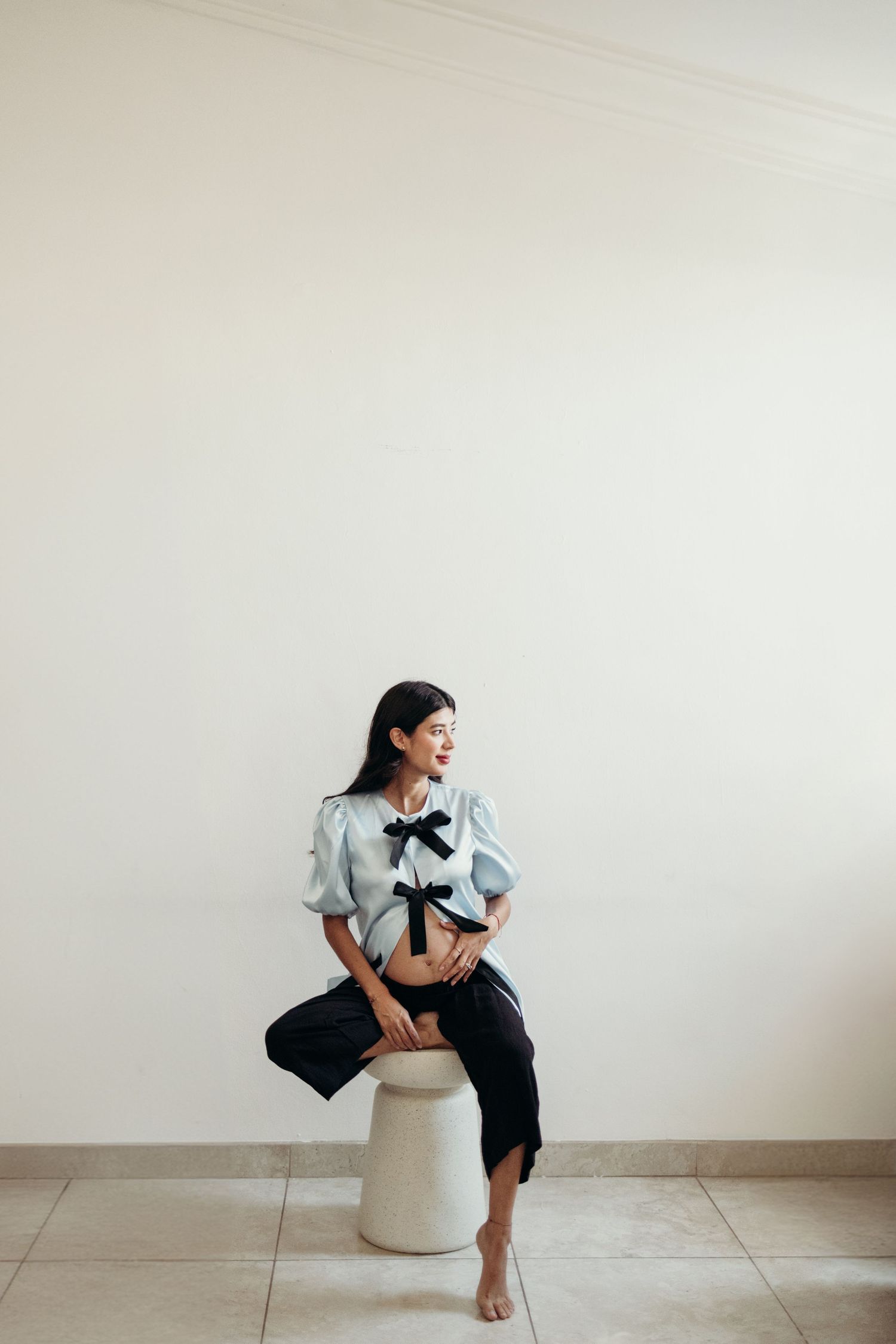 Monochromatic photo series featuring casual poses on white furniture and decor.