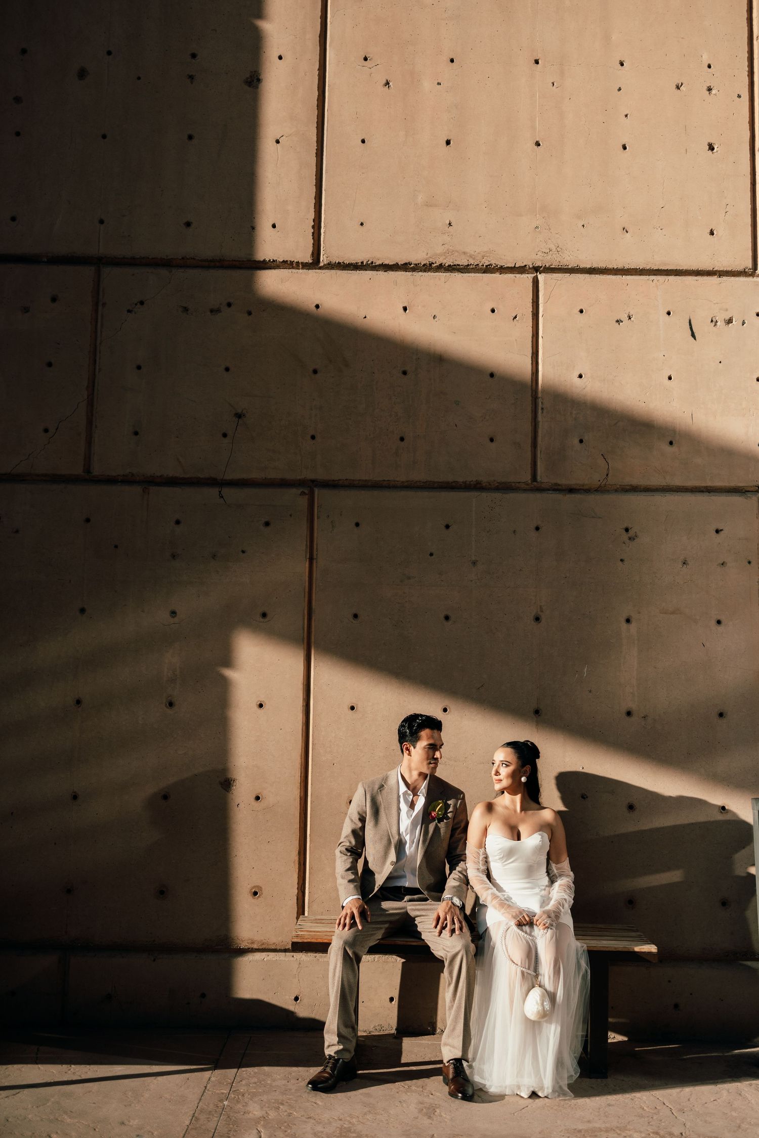 A sequence of wedding photos showing dramatic shadows and light on concrete walls with a couple in formal attire.