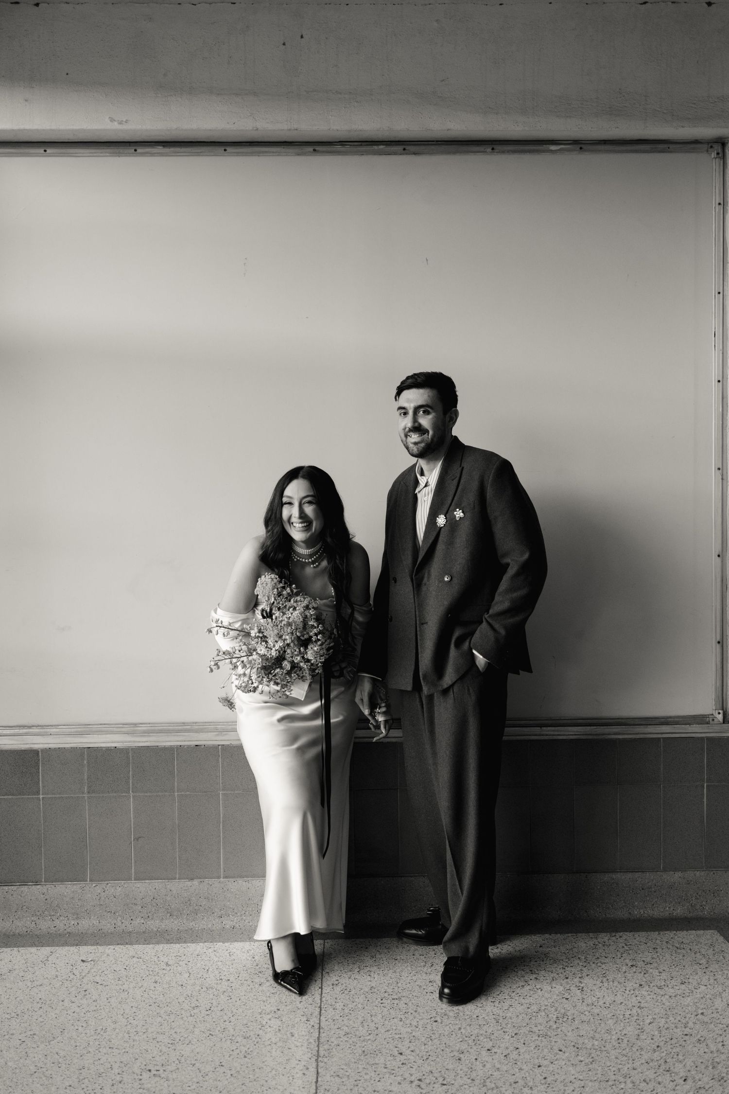 A black and white photo sequence shows a couple in formal attire posing against a wall in different positions.