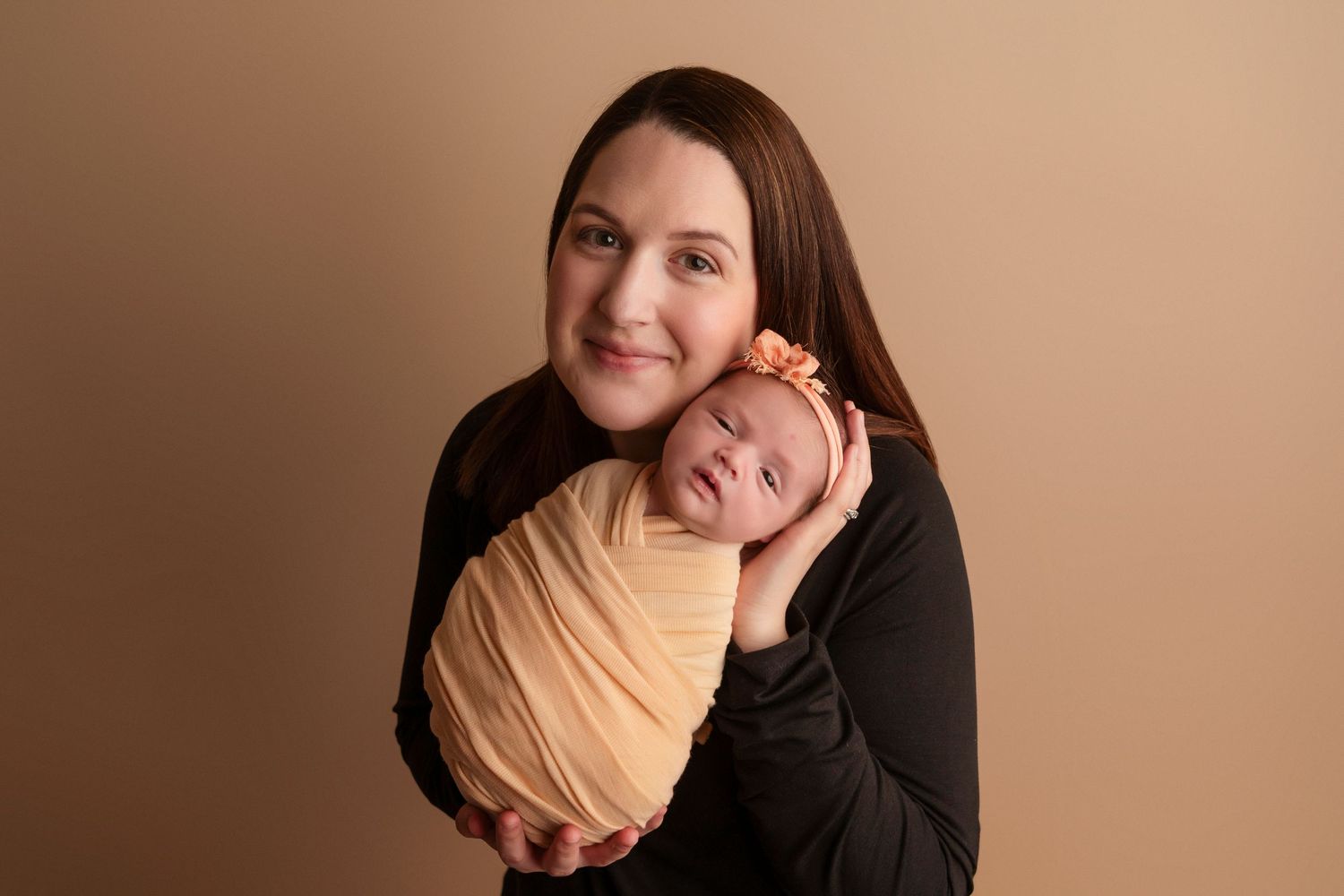 Series of heartwarming newborn photography poses with parent in black shirt against neutral backdrop.