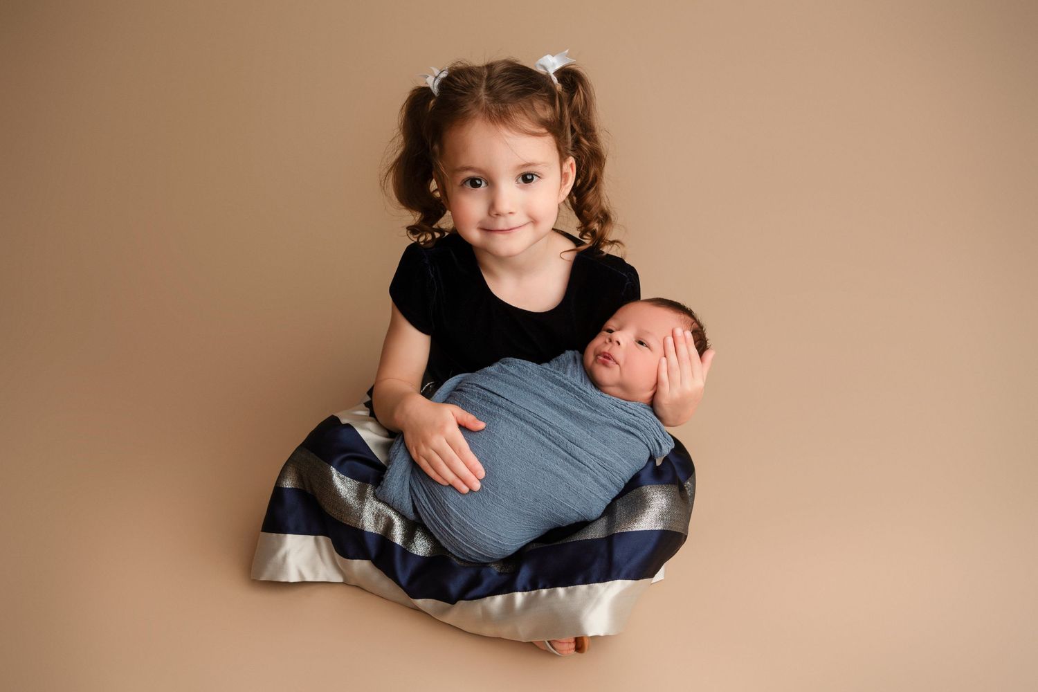 A series of seven newborn baby portraits in neutral tones showing various poses and angles on a beige backdrop.