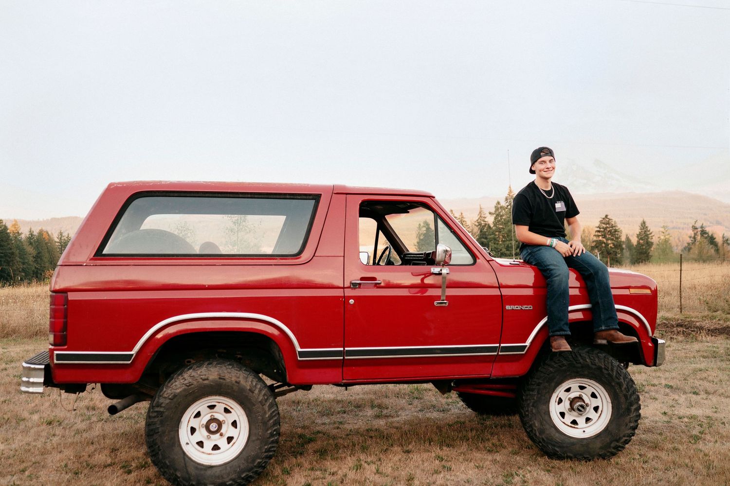 A red vintage Jeep Cherokee Chief SUV shown from multiple angles in a rural setting at sunset.