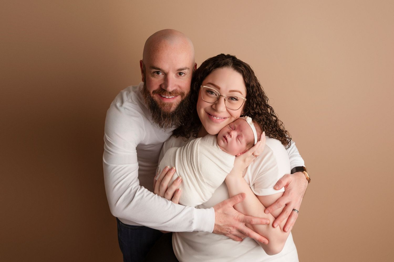 A collage of tender family portrait moments captured against a warm beige backdrop in a professional studio setting.