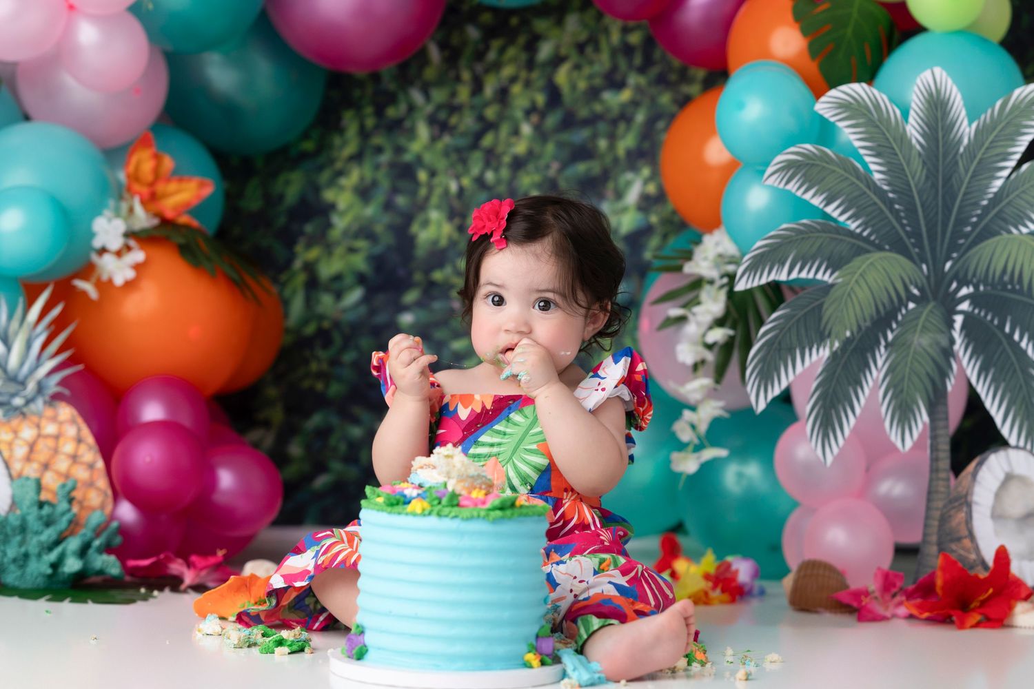 Colorful balloon arch with tropical decorations and party treats set up for a festive celebration.