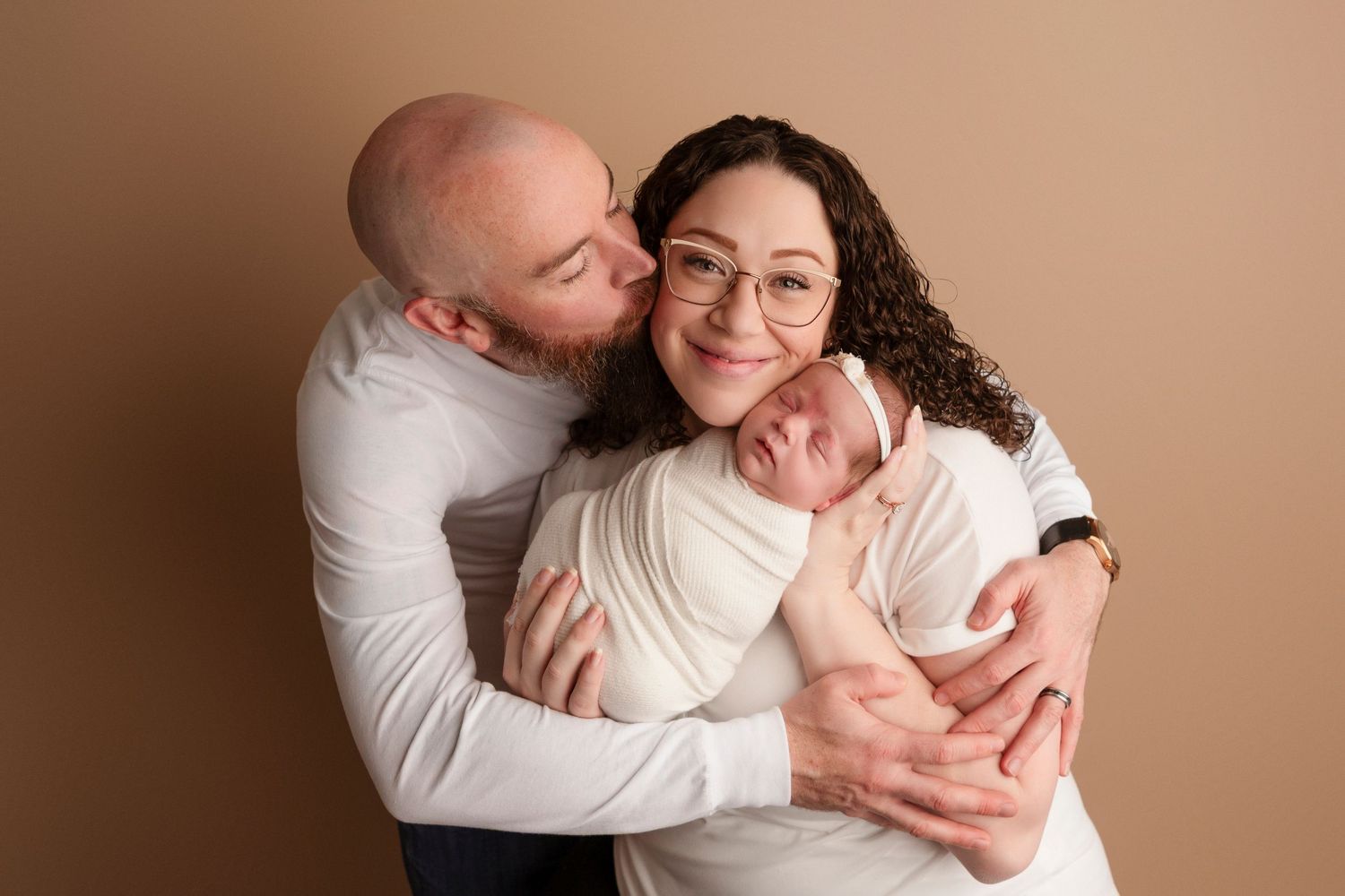 A loving couple embraces tenderly in a series of intimate poses against a neutral beige background.
