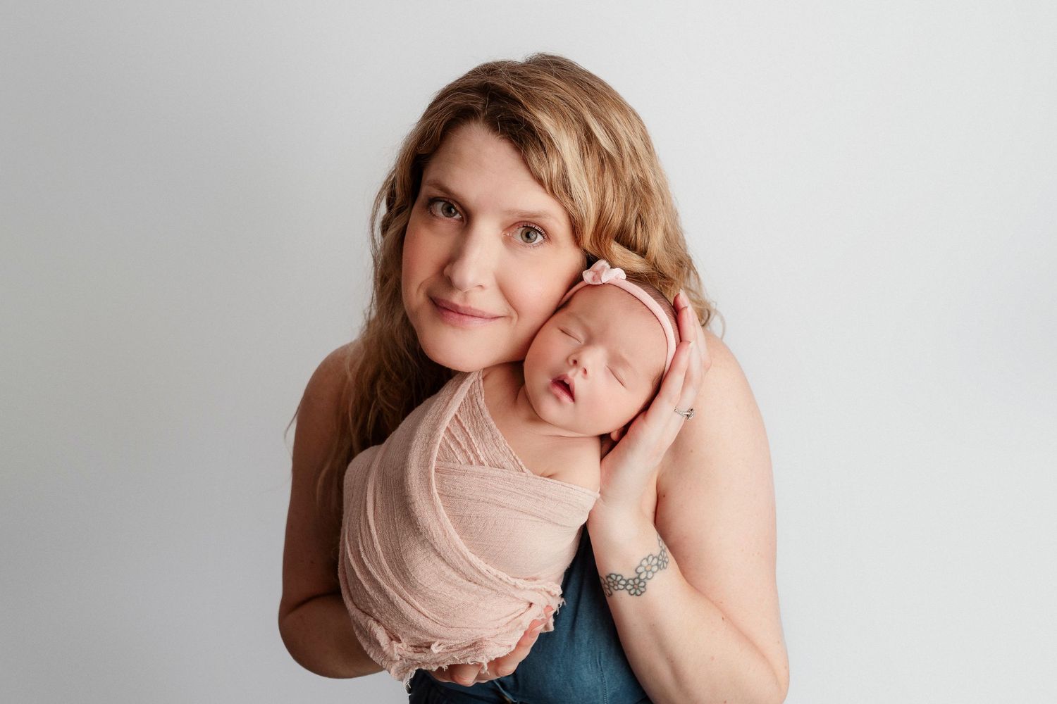 Professional studio portraits of someone in soft pink and blue tones against neutral backgrounds.