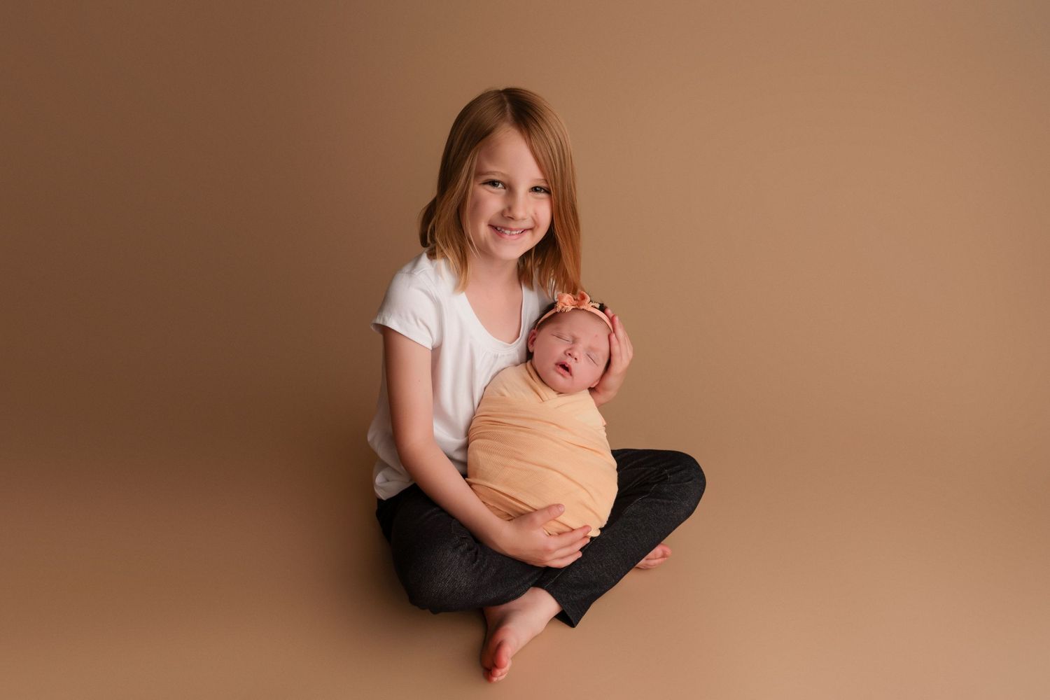 Candid portrait session showing joyful expressions and embraces against a neutral brown background.