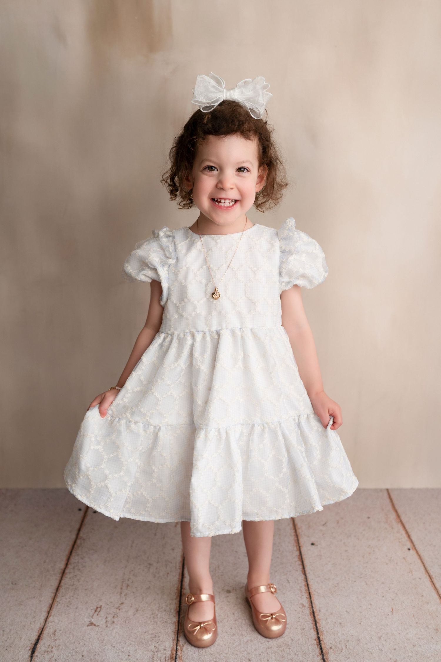Sweet white eyelet dress with puff sleeves and gold sandals shown in a series of photos against a neutral backdrop.