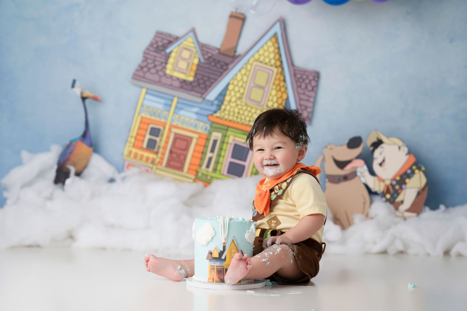 Baby in winter wonderland themed photo session with miniature colorful houses and snow props.