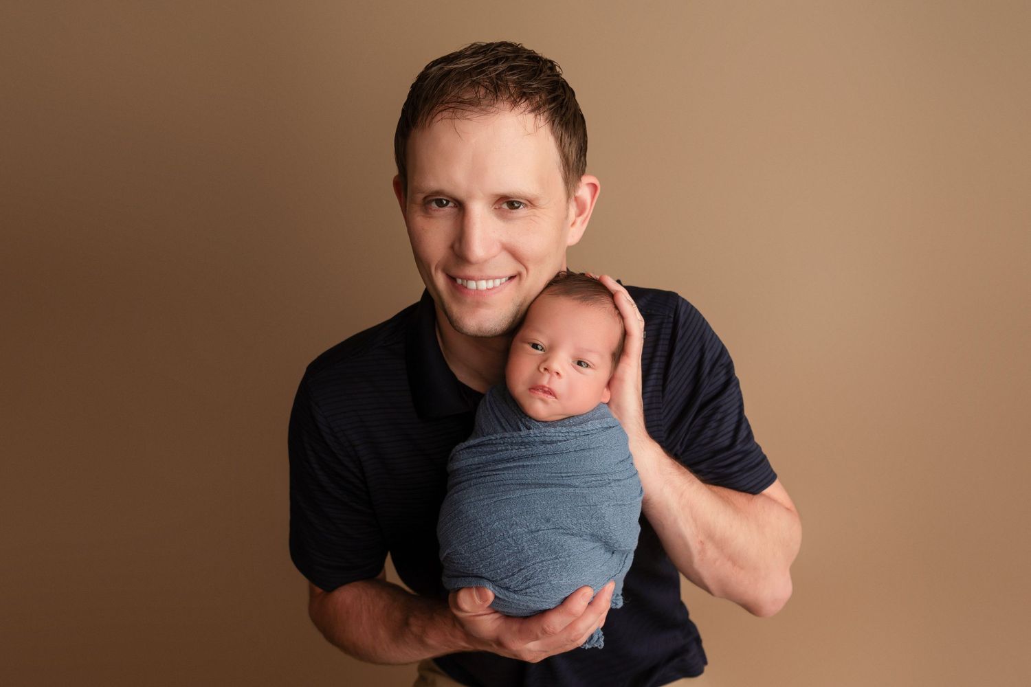 A series of six photos showing a parent and newborn baby in various tender poses against a brown backdrop.
