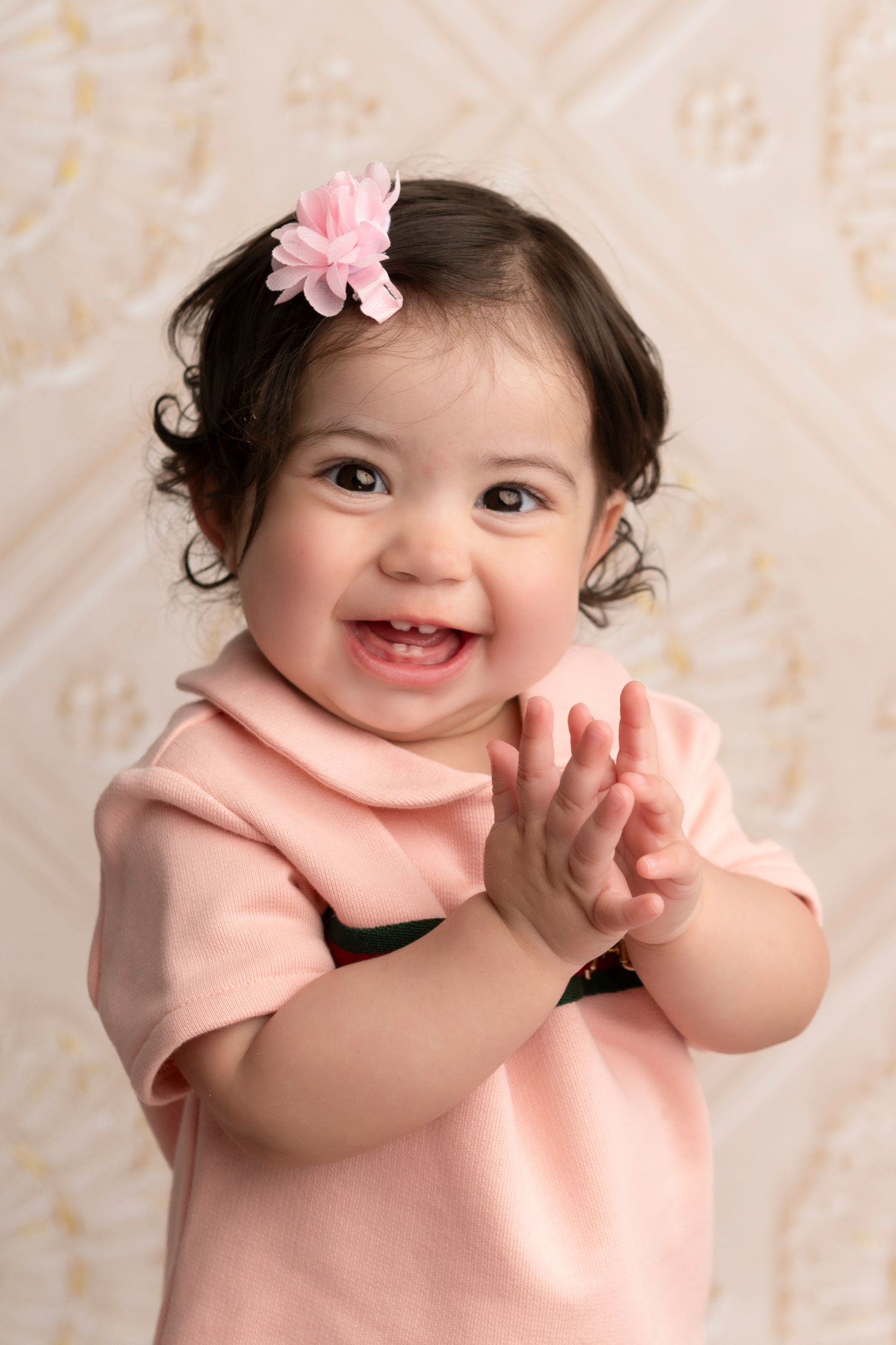 A baby wearing a pink outfit and flower hair clip shows various happy expressions in a photo collage.