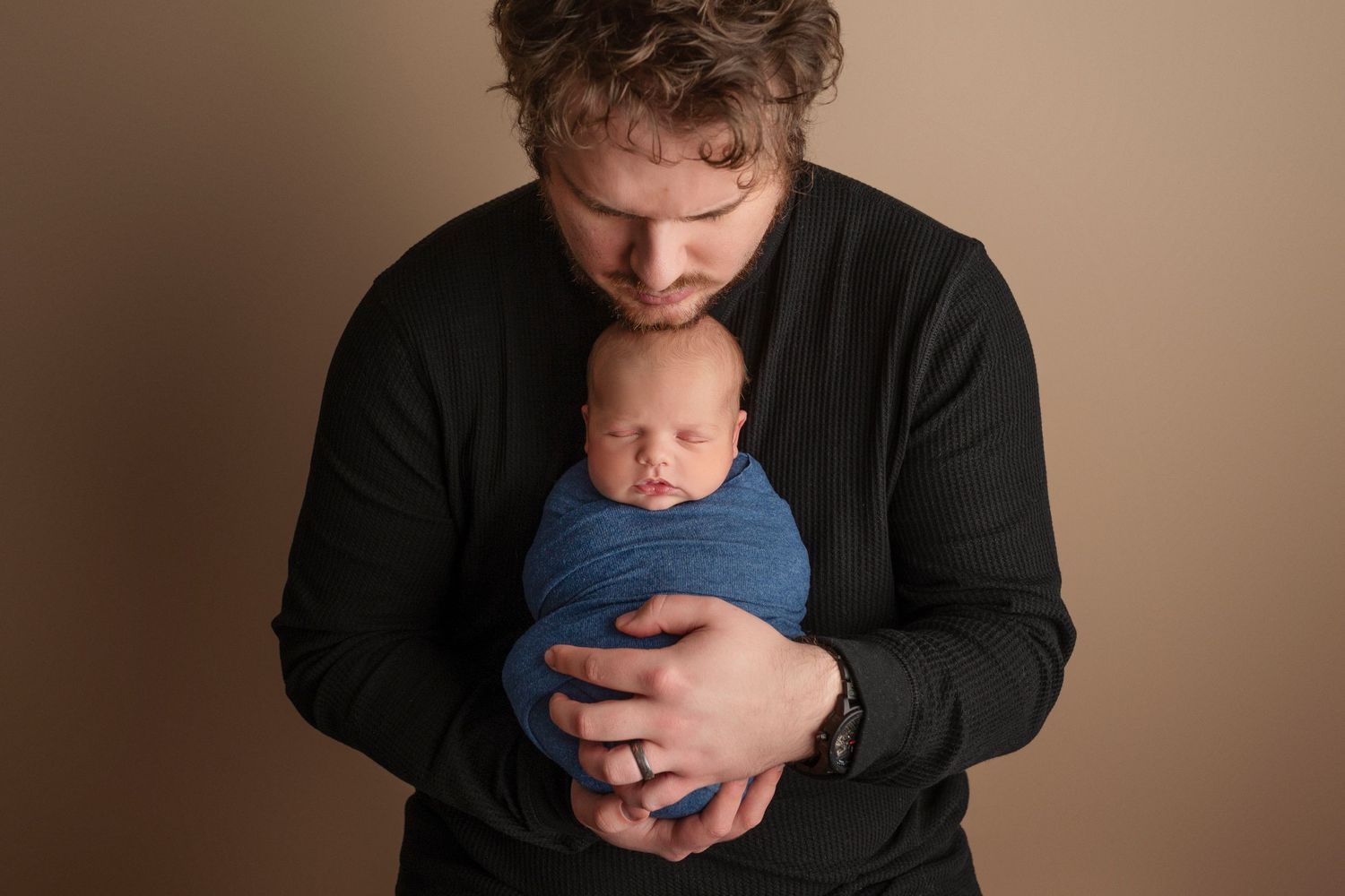A series of tender newborn photography portraits showing parent holding baby in gentle poses against neutral backdrop.