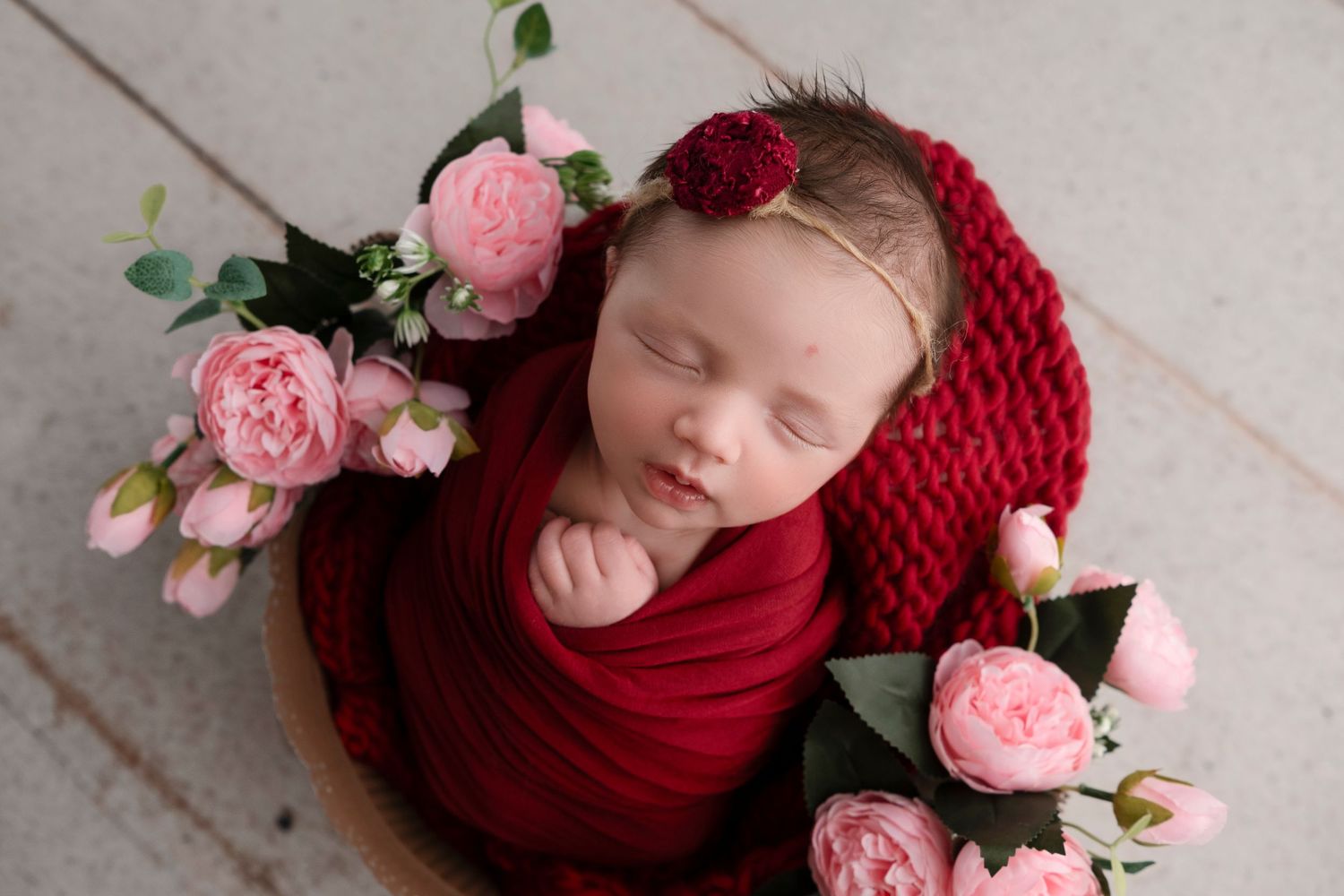 Newborn photography collage featuring burgundy wrap and delicate pink roses in a soft studio setting.