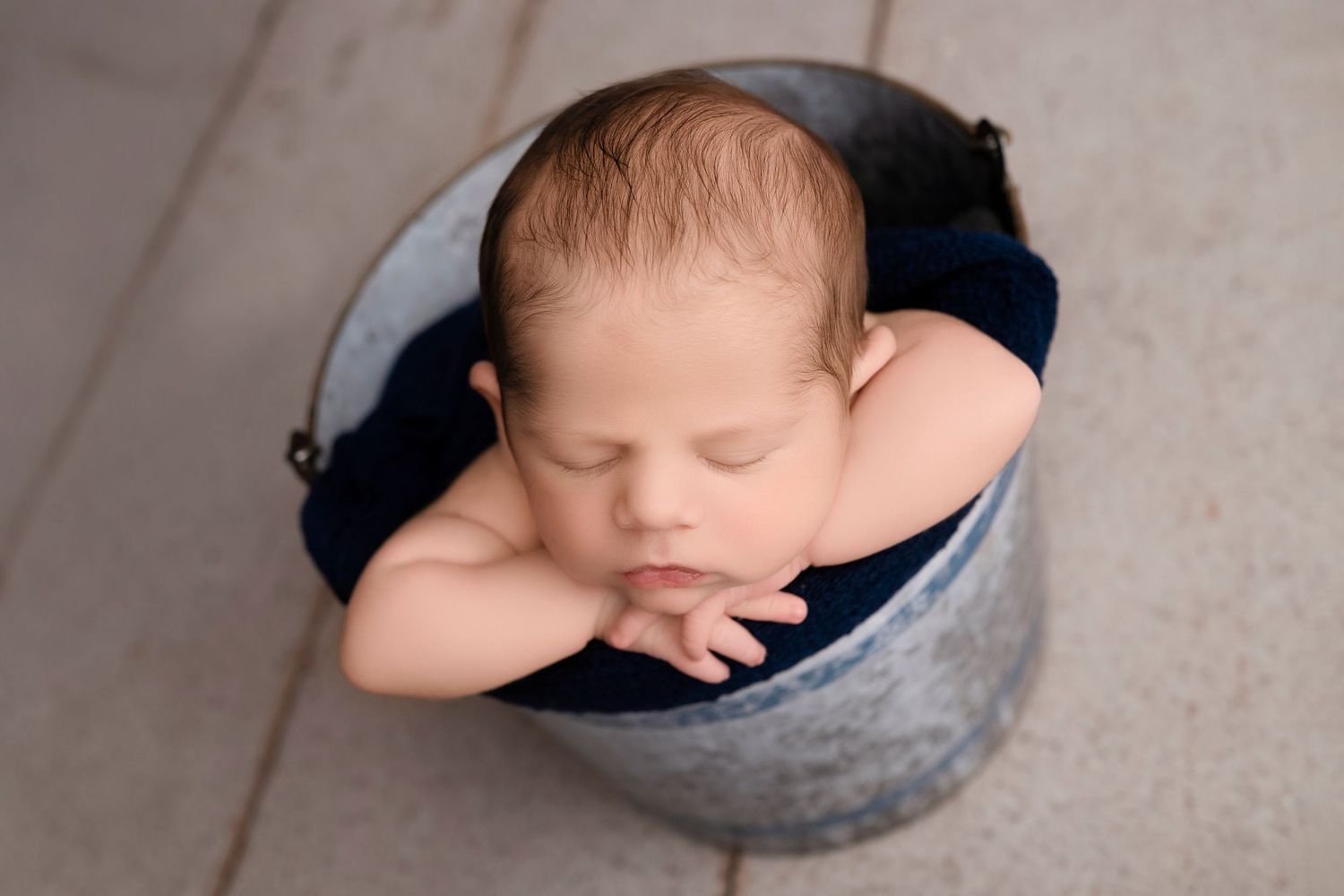 Series of gentle newborn poses in navy and grey tones with minimalist styling.