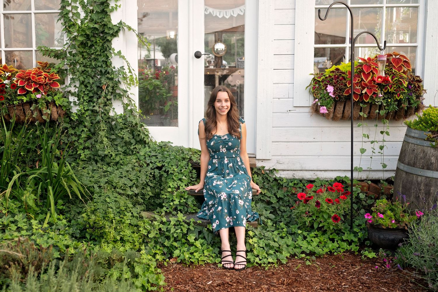 A series of connected photos showing a garden tour around a white house with red flowers and lush greenery.
