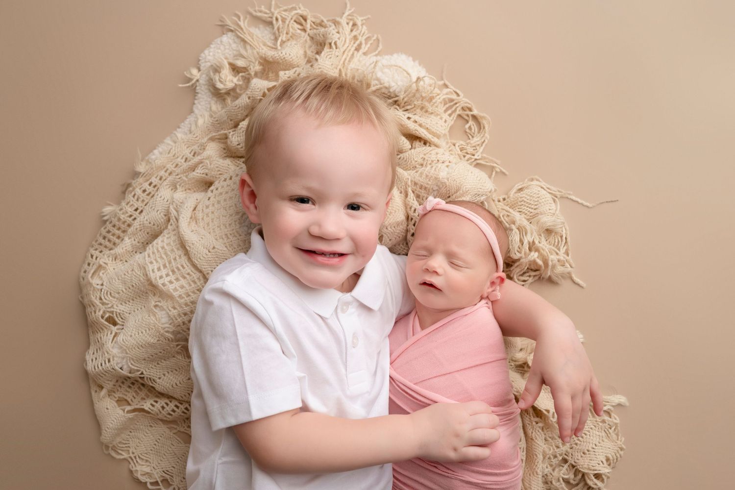 A series of soft, neutral-toned newborn photography portraits showing tender sibling moments in a studio setting.
