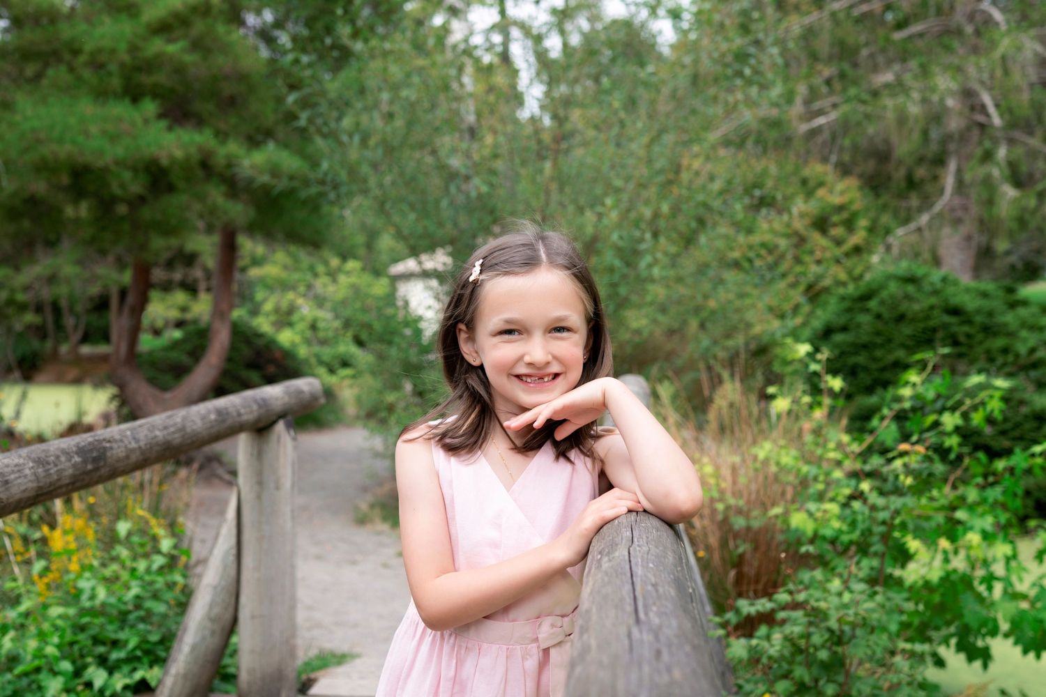 A series of outdoor photos showing someone in a pink dress walking through a lush garden path in summer.