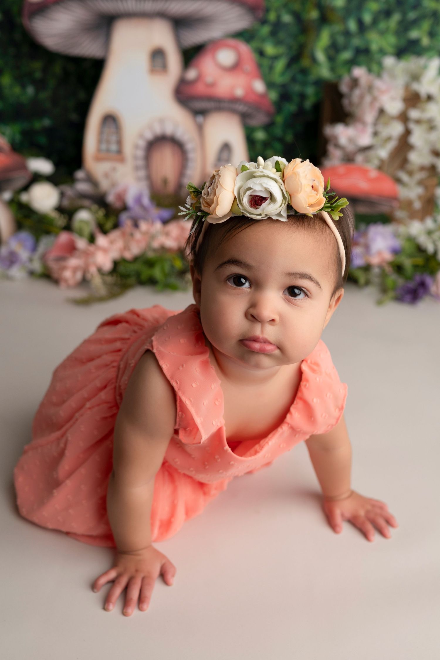 Enchanting fairy-tale inspired photo scene with coral dress and decorative mushroom elements.