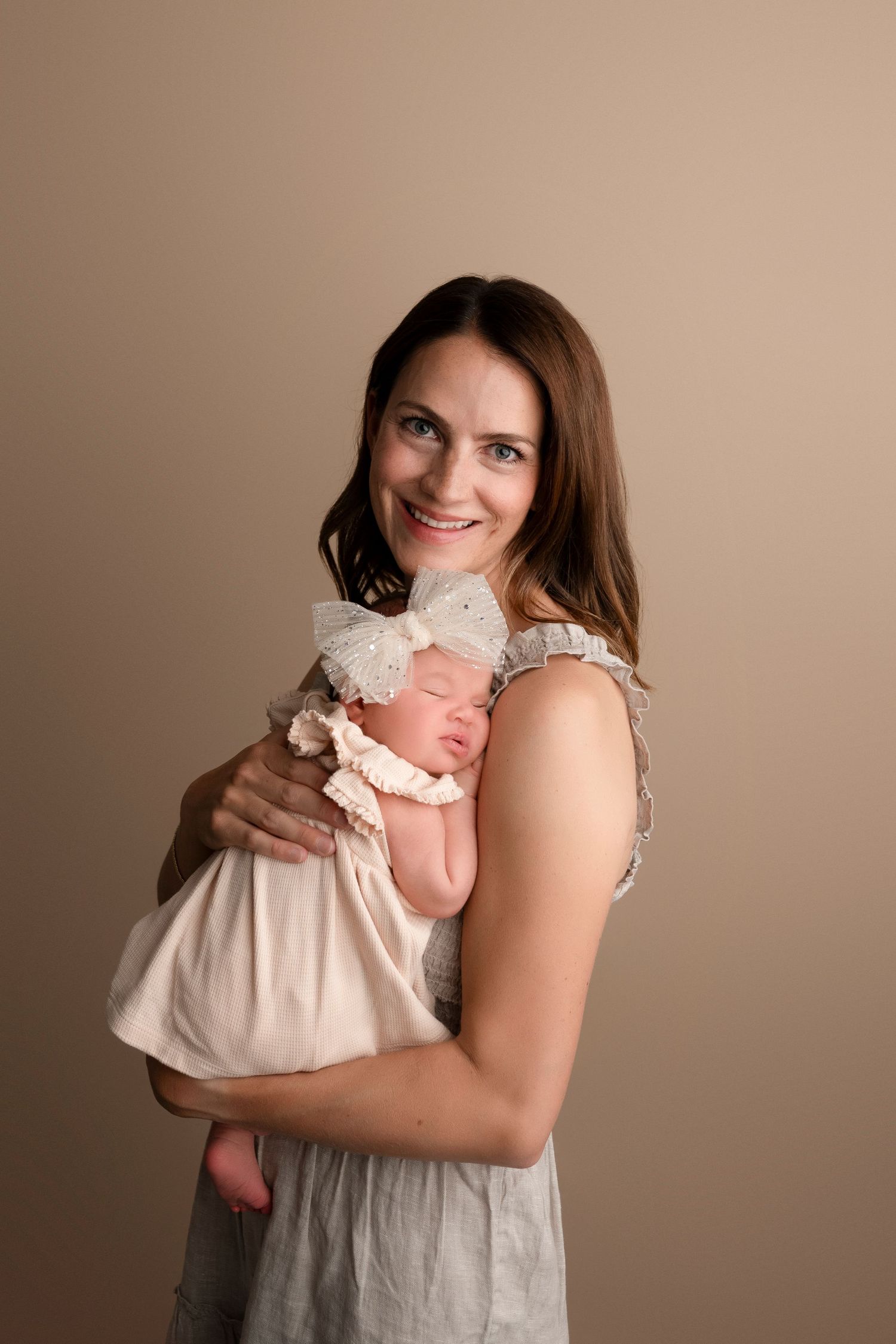 A series of tender moments captured between a mother and baby in soft beige tones during a portrait photography session.