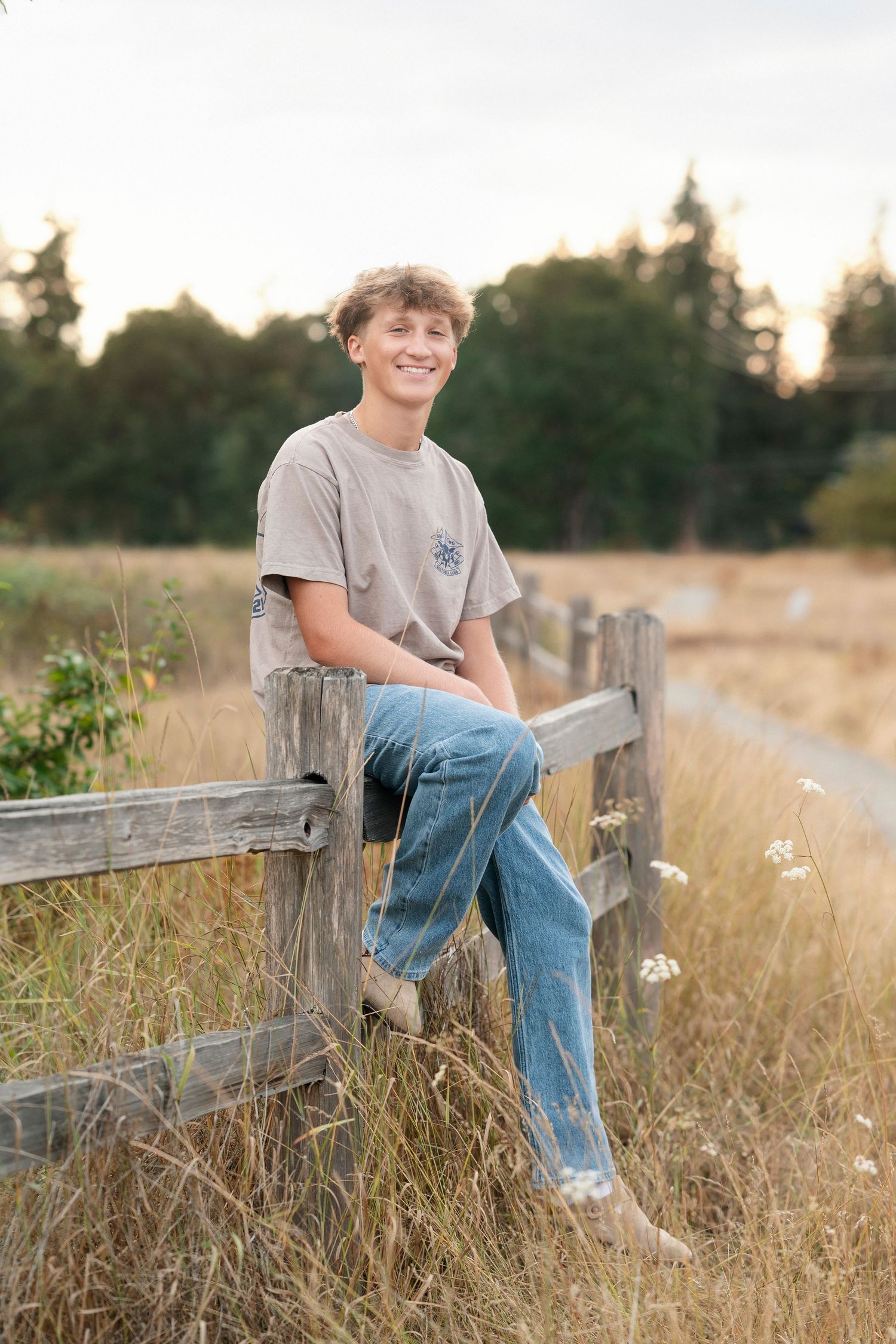 A casual outdoor portrait series of someone sitting on a rustic wooden fence in a golden grassy field at sunset.