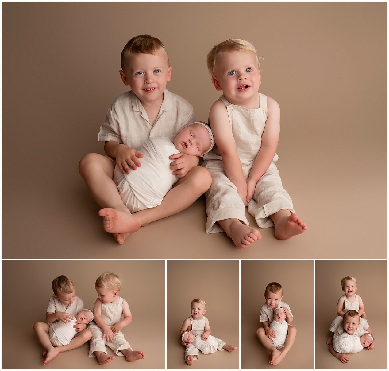 Two toddlers in matching white outfits sit and play together in a warm-toned studio setting.