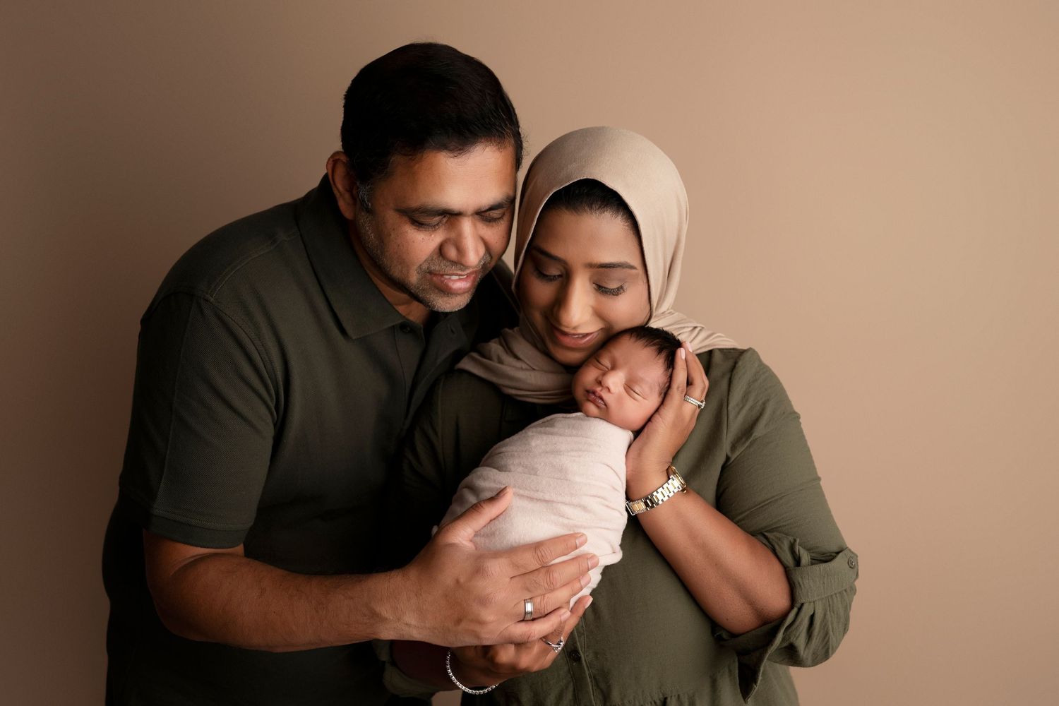 A series of tender moments between parents and their newborn baby shown in six connected photographs.