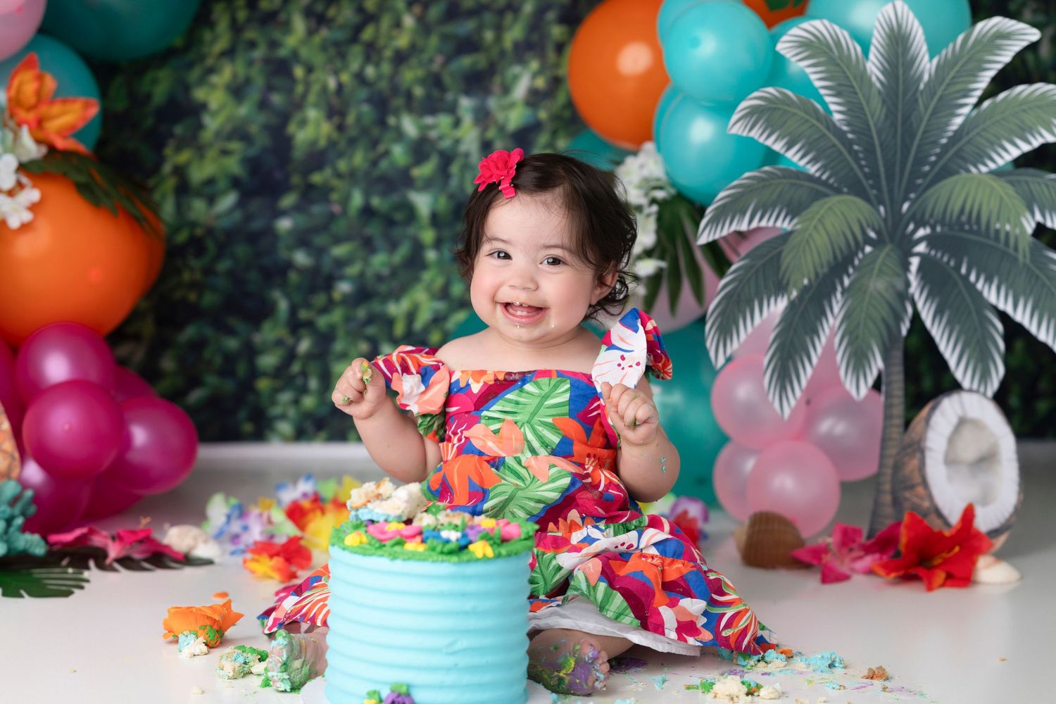 Colorful tropical party setup with teal and orange balloons, palm tree decorations, and festive party decorations.
