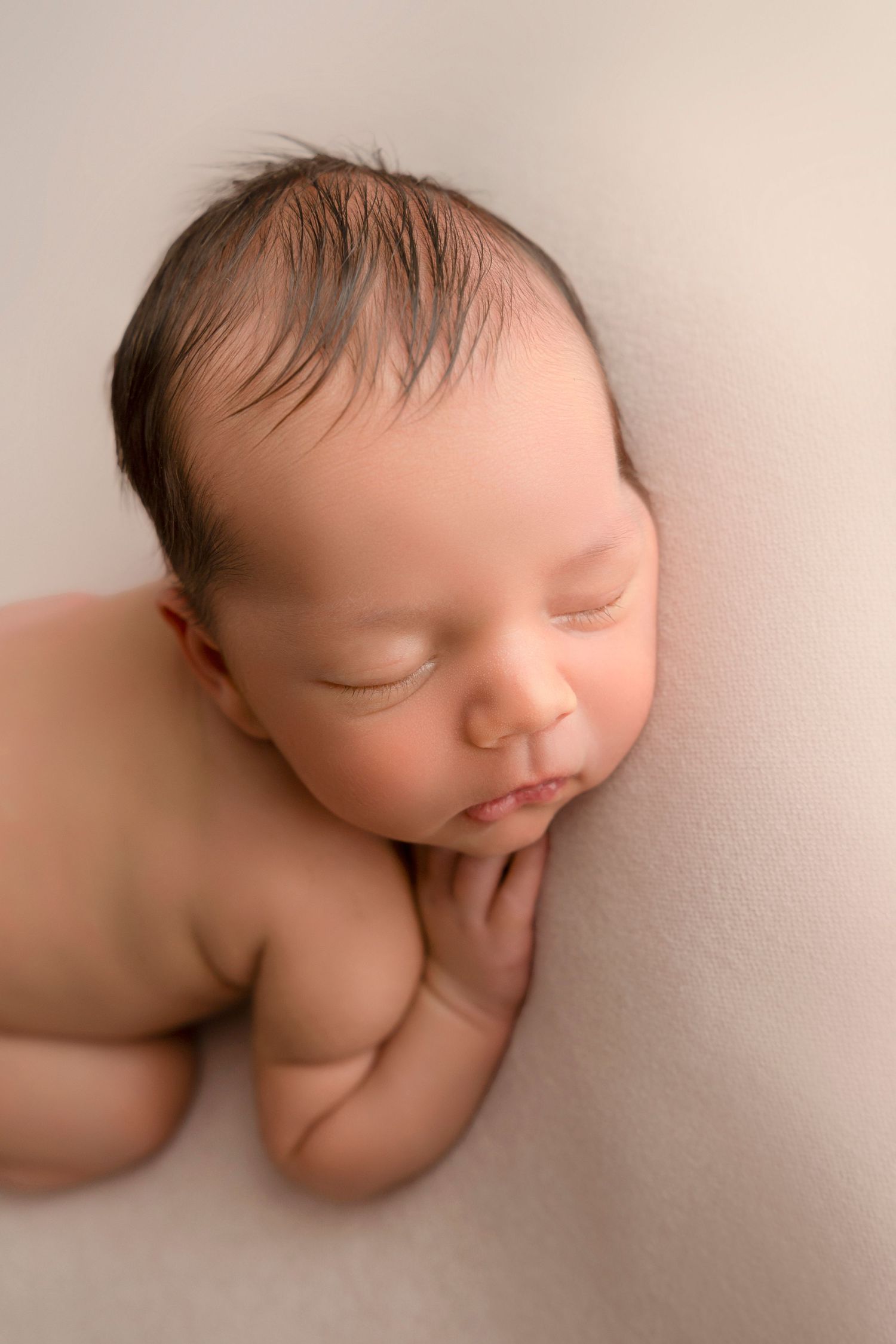 Artistic series of soft-focus photos showing a sleeping newborn baby in gentle, neutral tones.
