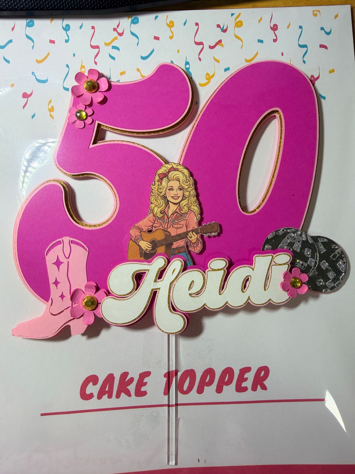 Pink 50th birthday cake topper for Heidi featuring Dolly Parton, cowboy boots, hat, and floral accents.