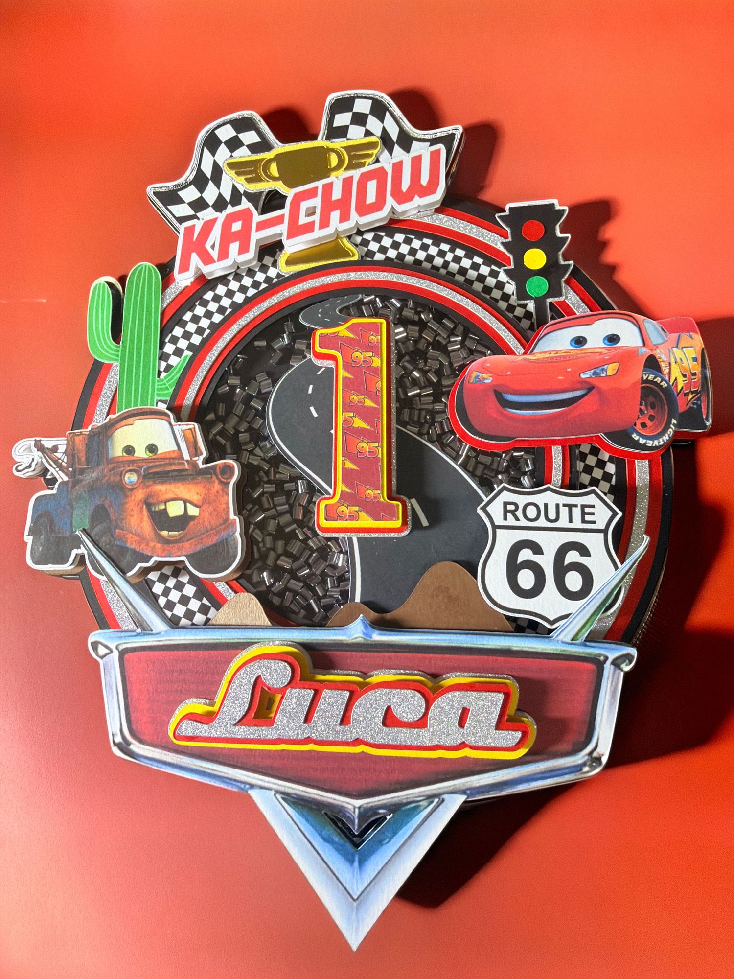 Disney Cars themed 1st birthday decoration for Luca featuring Lightning McQueen, Mater, Route 66, and Ka-Chow signage.