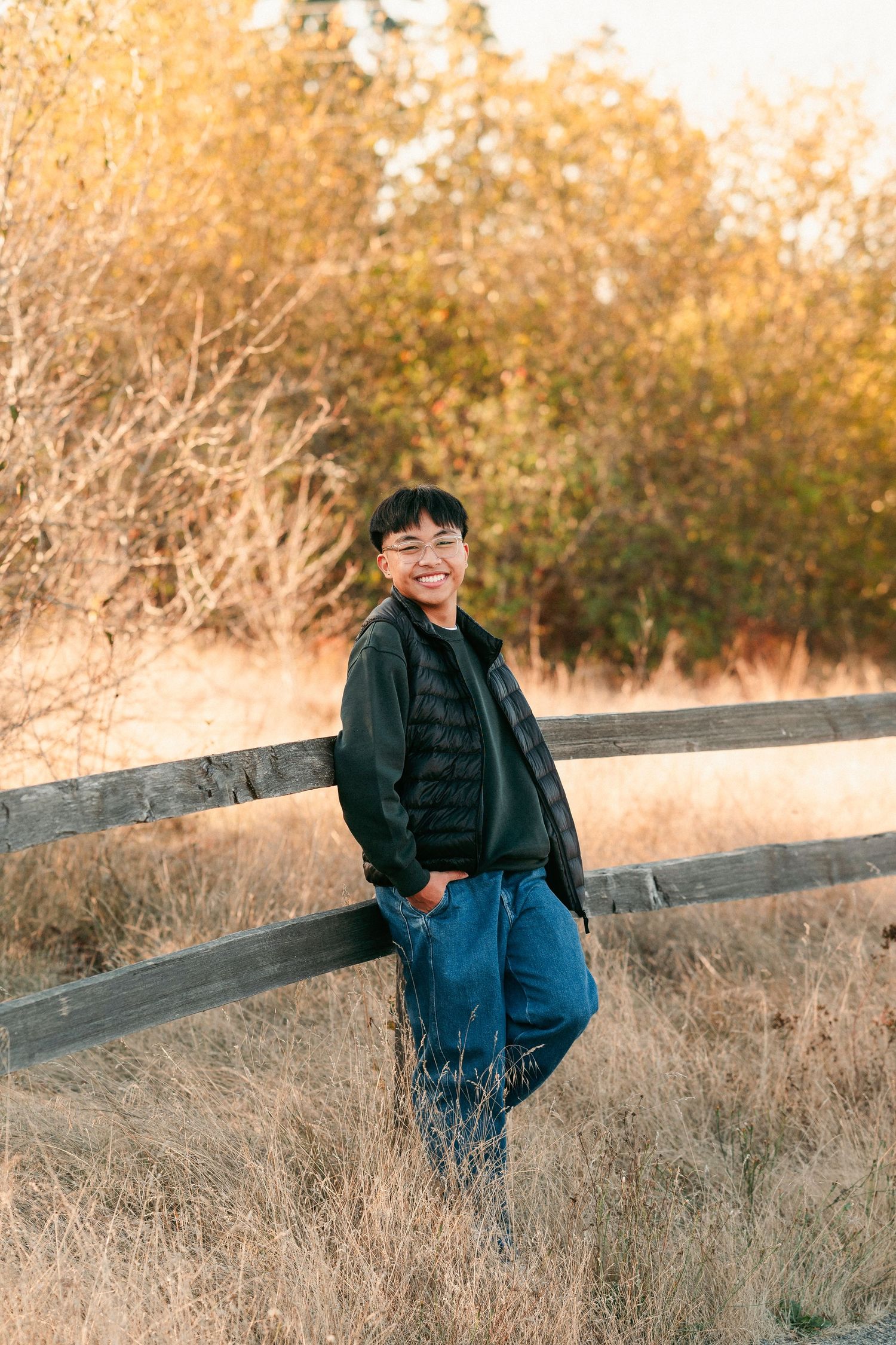 A series of outdoor portraits against a rustic wooden fence with autumn foliage in the background.