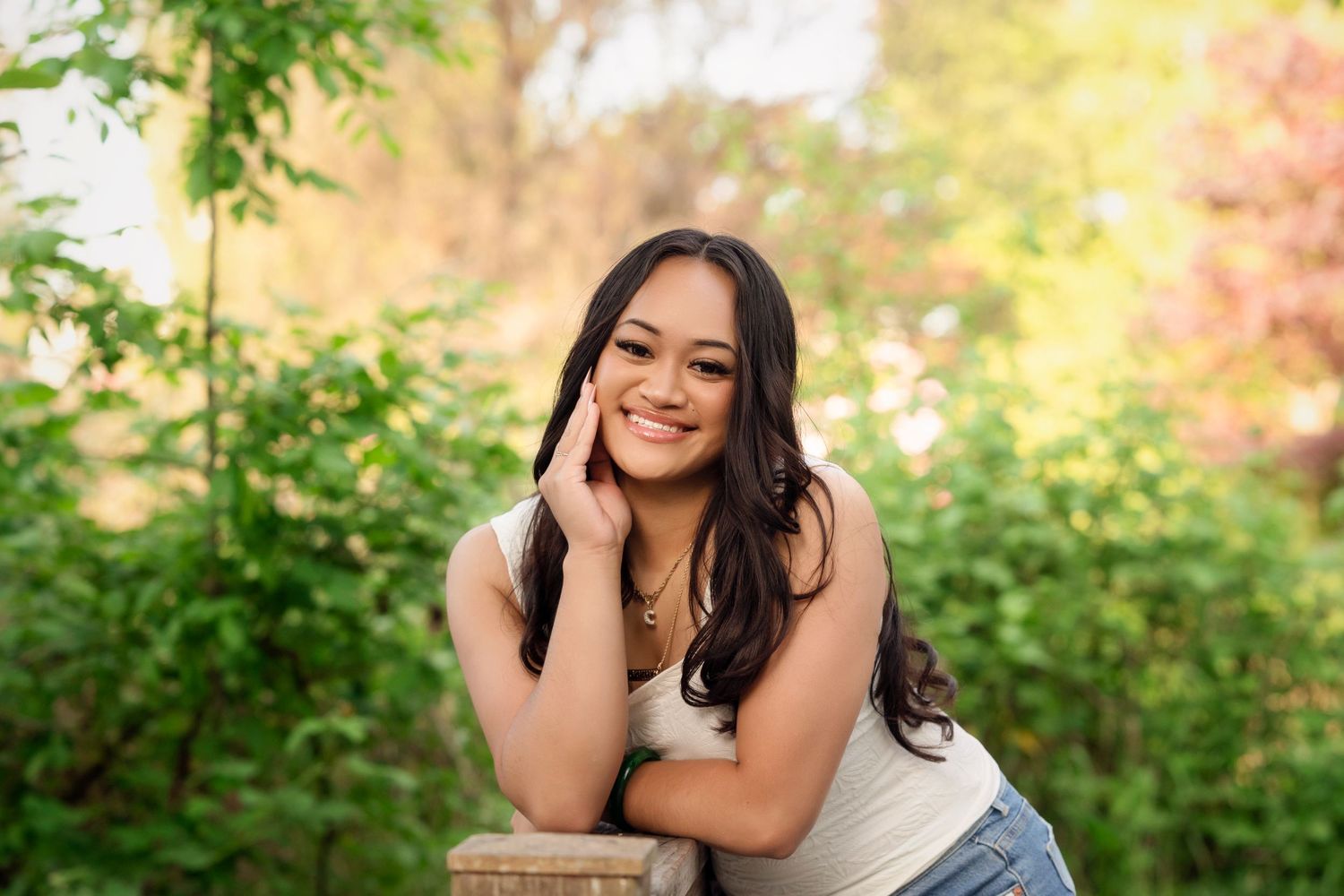 A series of outdoor portrait photos taken in a lush garden setting with green foliage and autumn colors in the background.