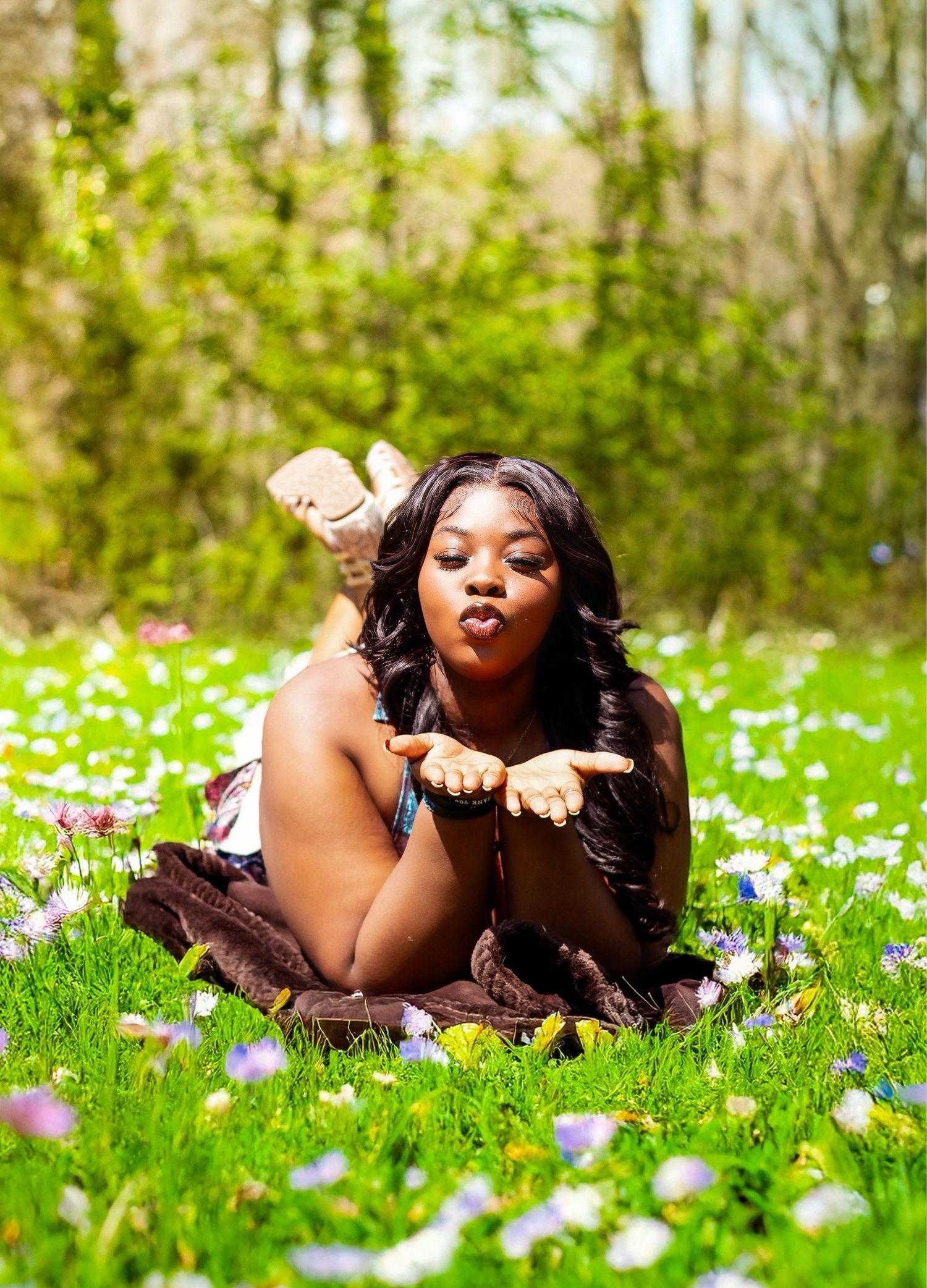 A person relaxes in a field of purple wildflowers on a sunny spring day.