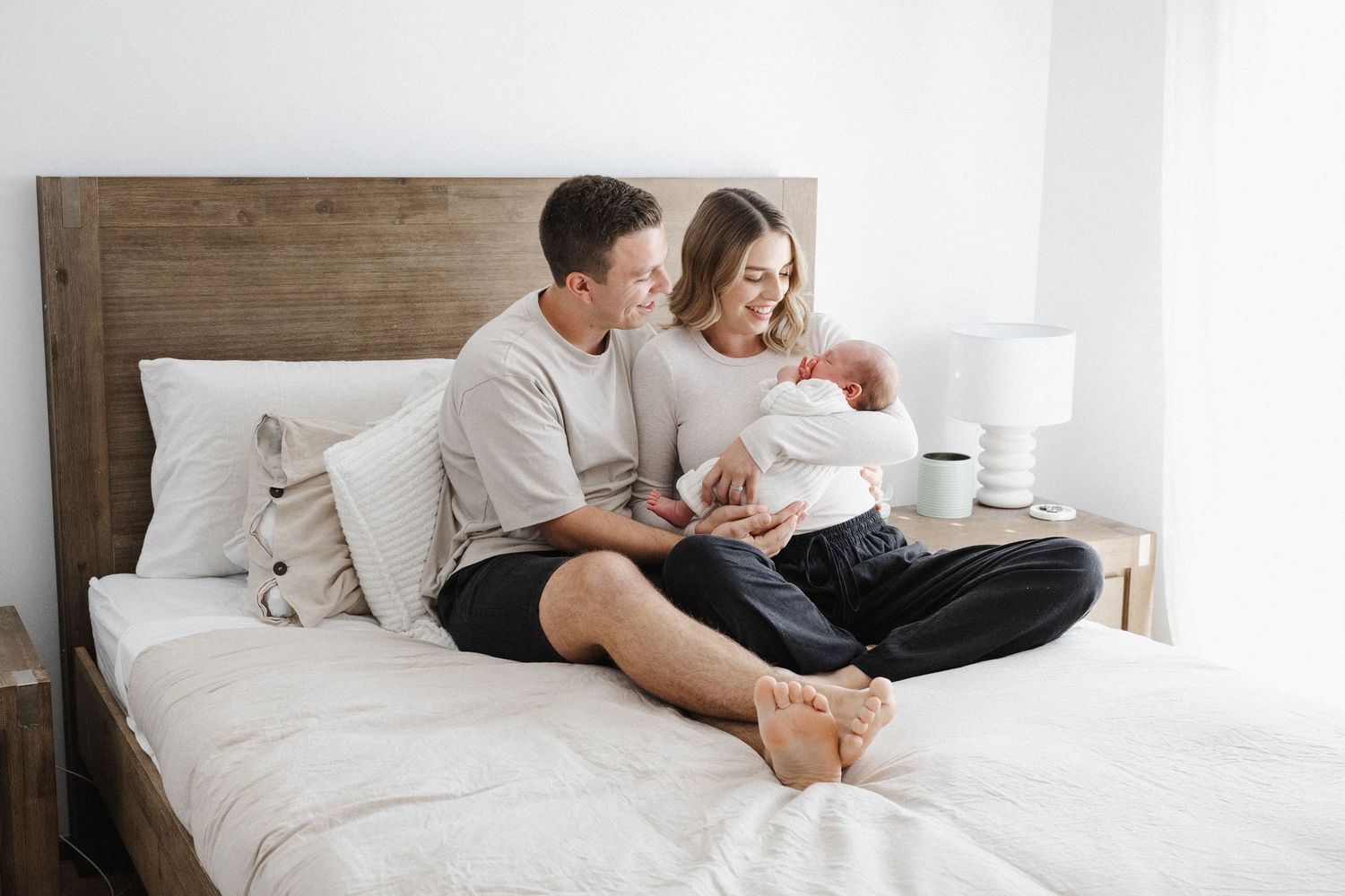 Newborn baby cuddled by his parents in bed in Canberra